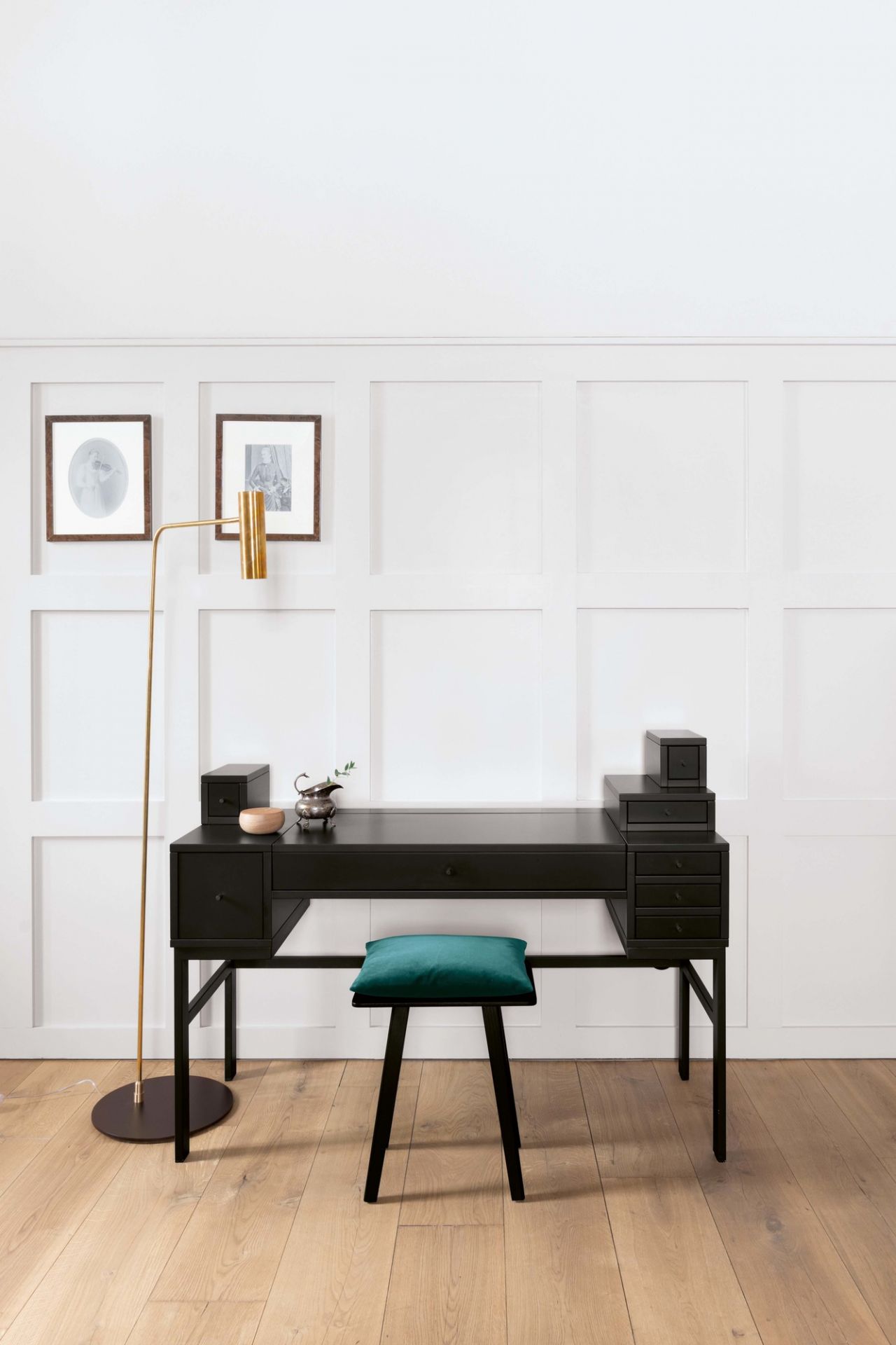 Schwarzer Schminktisch mit Schubladen und grünem Nini Hocker von Schönbuch, ergänzt durch goldene Stehlampe.