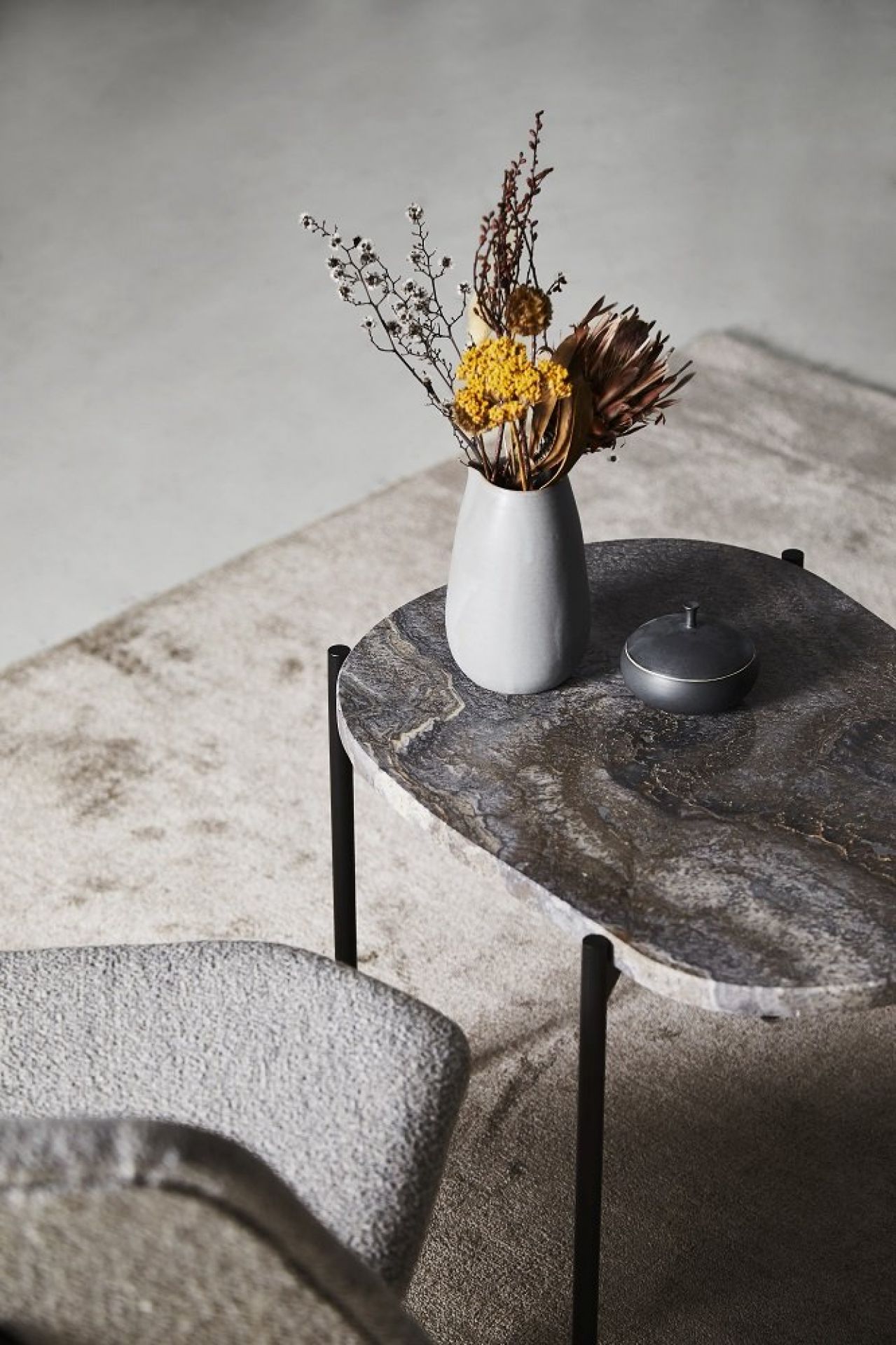 La Terra Couchtisch von Woud, Medium, Grau melange mit Blumen und Dose auf Teppich.