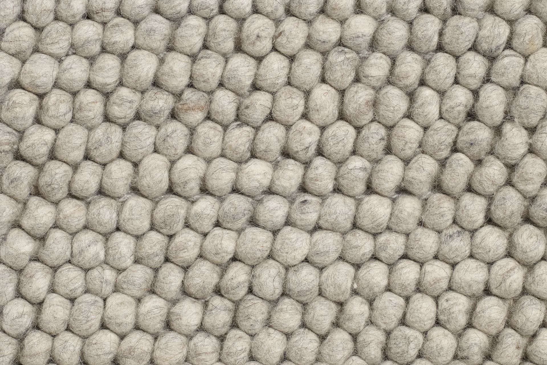 Detailaufnahme des Hay Peas Teppichs, L 200 x B 140 cm, in soft grau. Wollteppich mit erbsenförmiger Struktur.