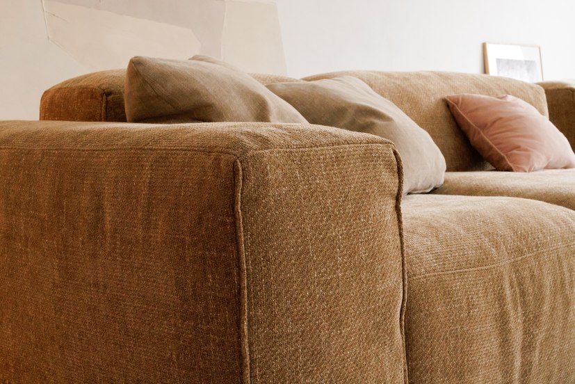 Detailaufnahme: Seatlife Sofa, Hausmodell, modernes Design, brauner Stoffbezug und Kissen.