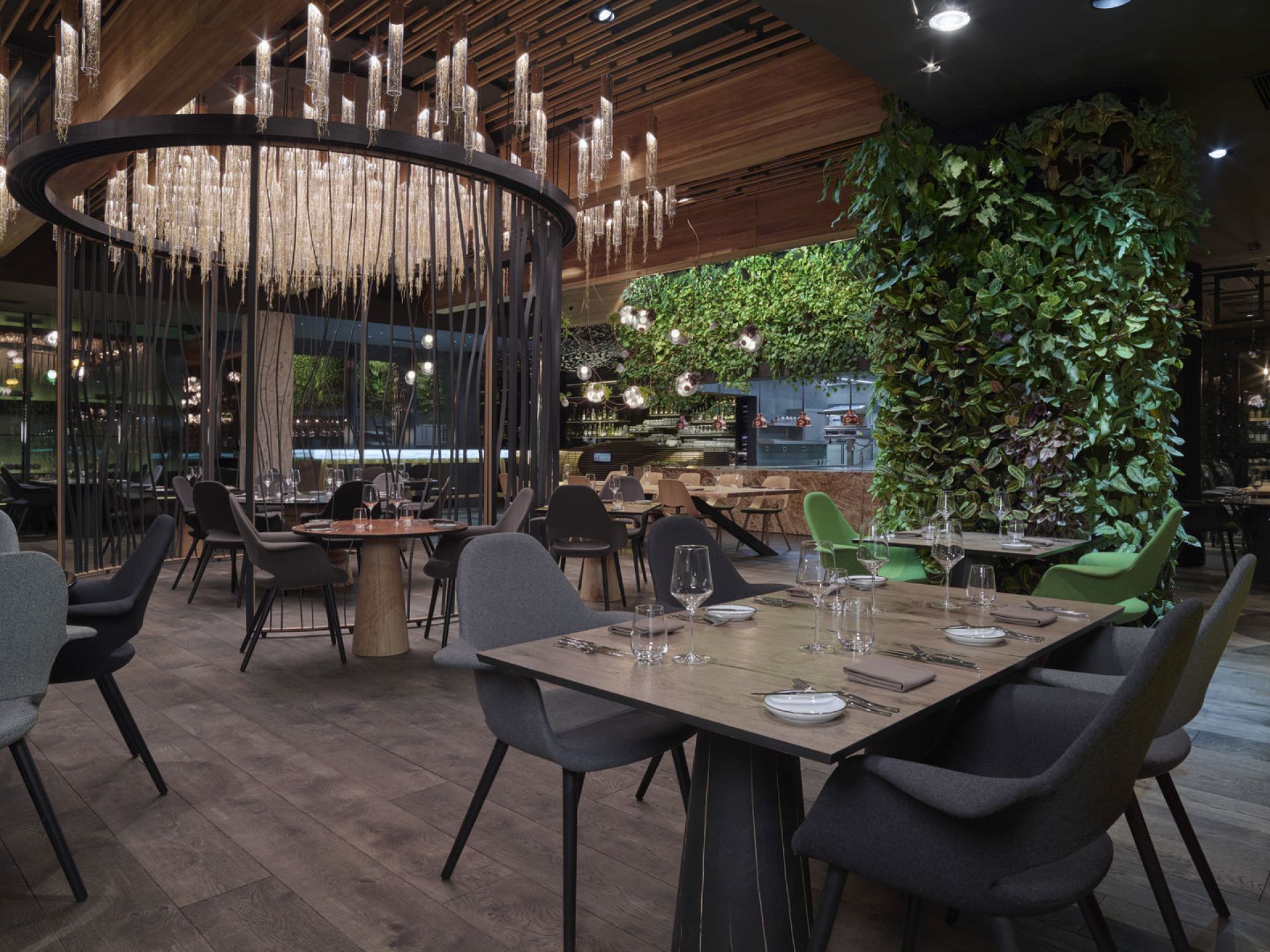 Innenaufnahme eines Restaurants mit Tischen und Stühlen, darunter graue Organic Conference Stühle von Vitra.