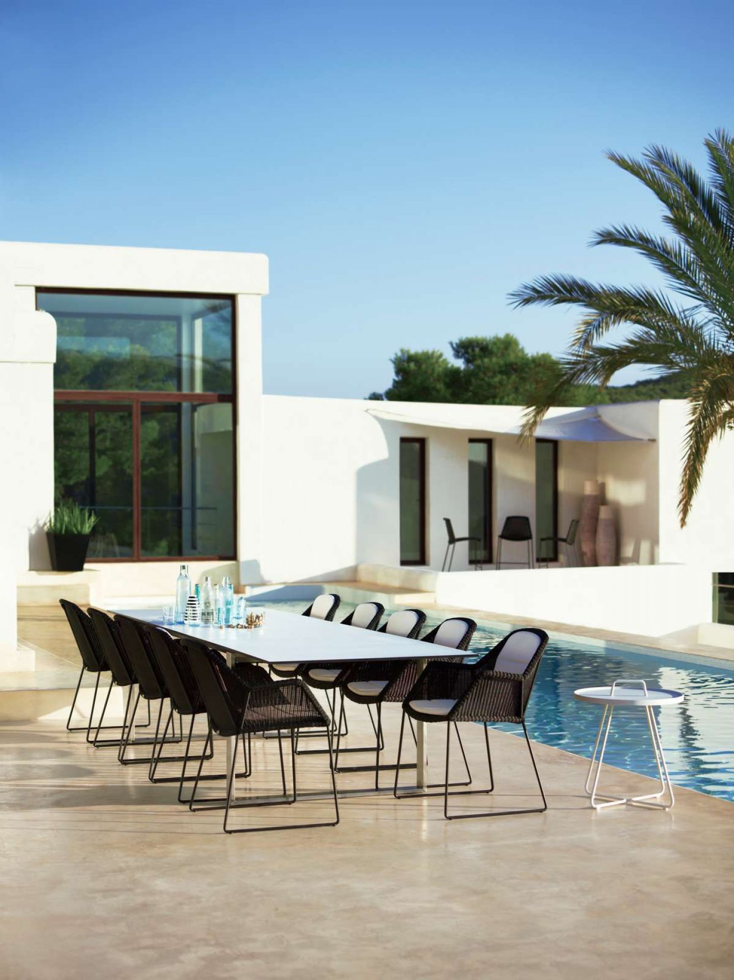 Breeze Outdoor Stühle von Cane-Line am Pool. Moderne Gartenstühle mit Kufengestell.