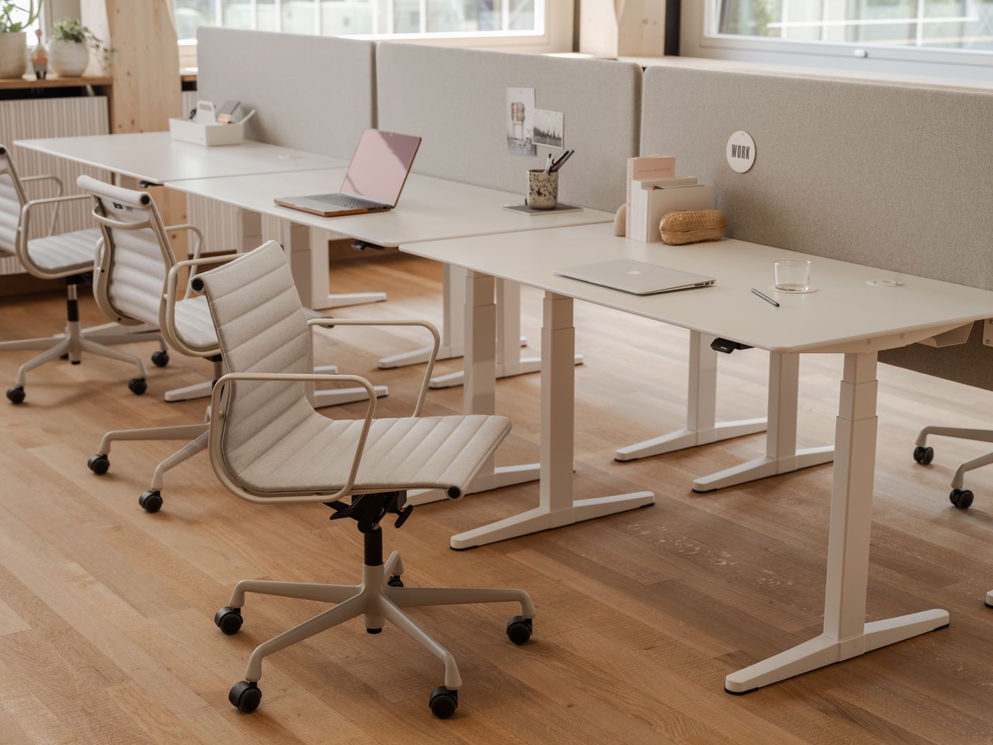 Nahaufnahme eines Aluminium Chair EA 118 von Vitra in einem modernen Büro mit höhenverstellbaren Schreibtischen.