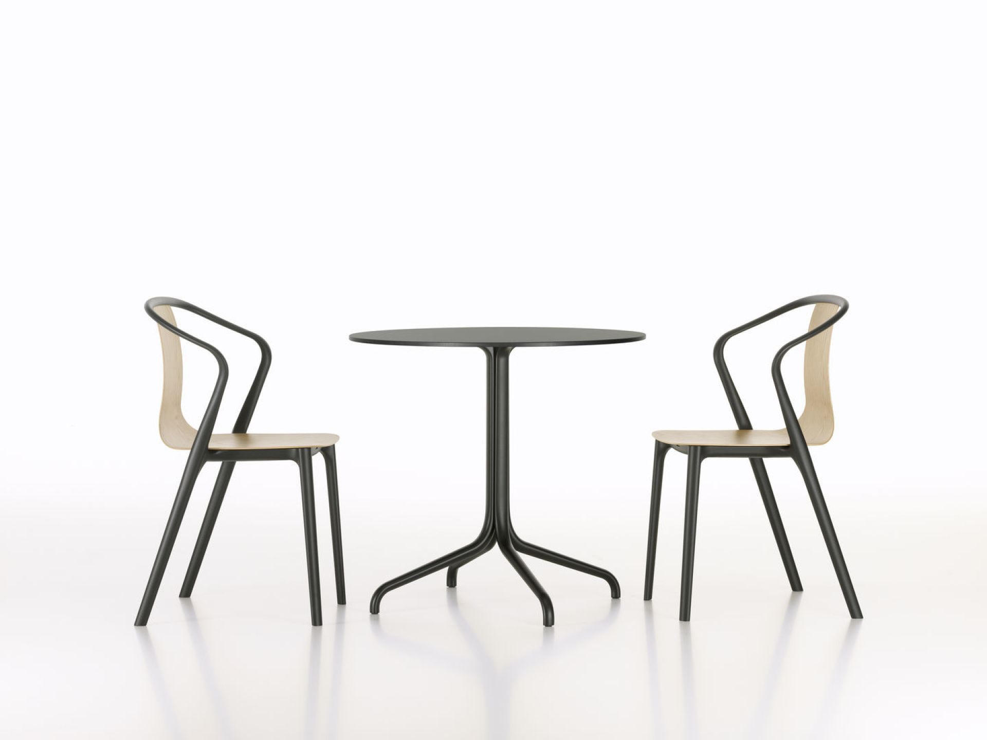Zwei Belleville Chair Wood Stühle von Vitra mit Holzsitz und schwarzem Gestell an Tisch.
