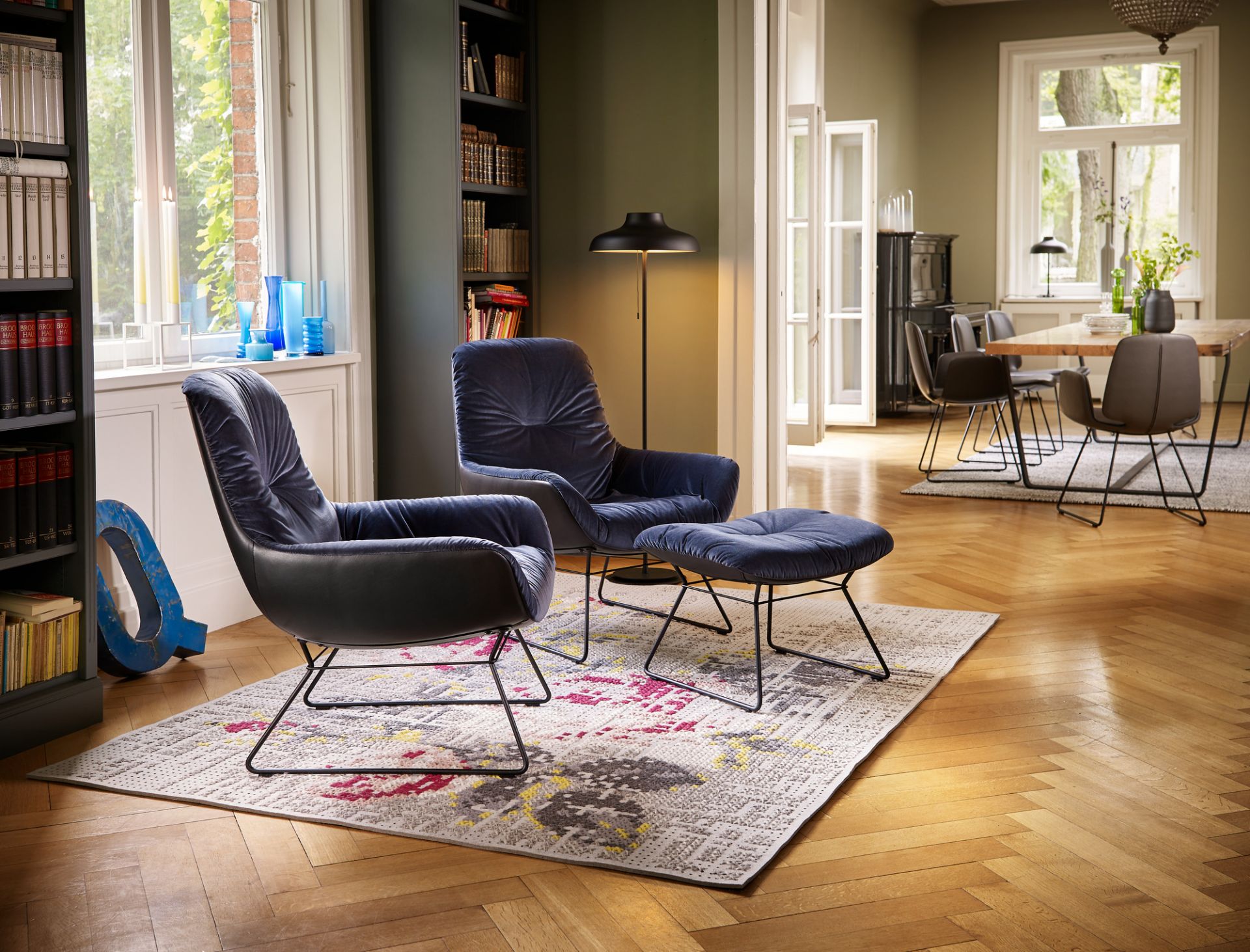 Blauer Leya Cocktail Sessel von Freifrau Manufaktur mit Hocker in stilvollem Wohnzimmer.