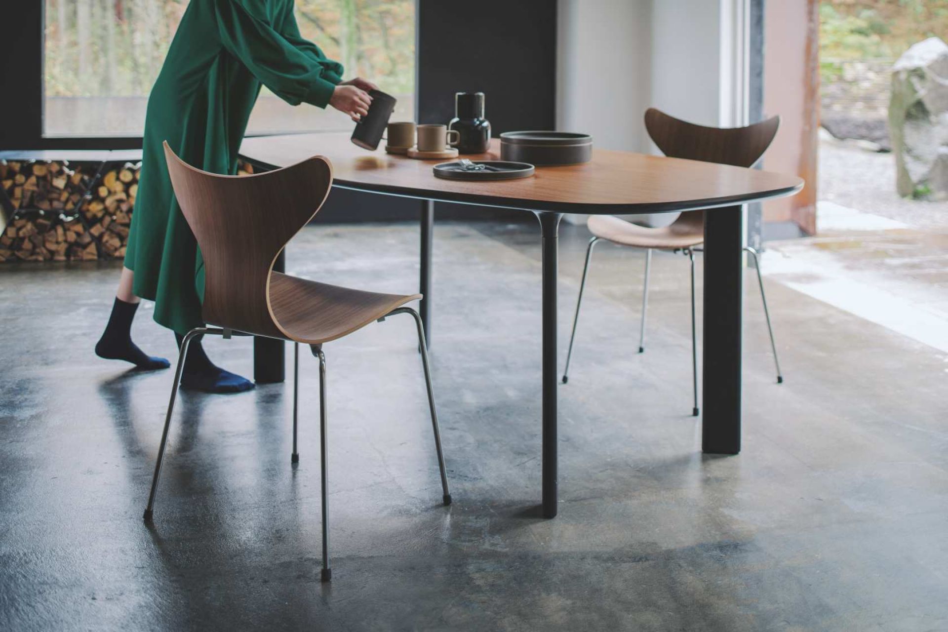Lily Stuhl von Fritz Hansen am Esstisch, skandinavisches Design mit Holzschale und Stahlbeinen.