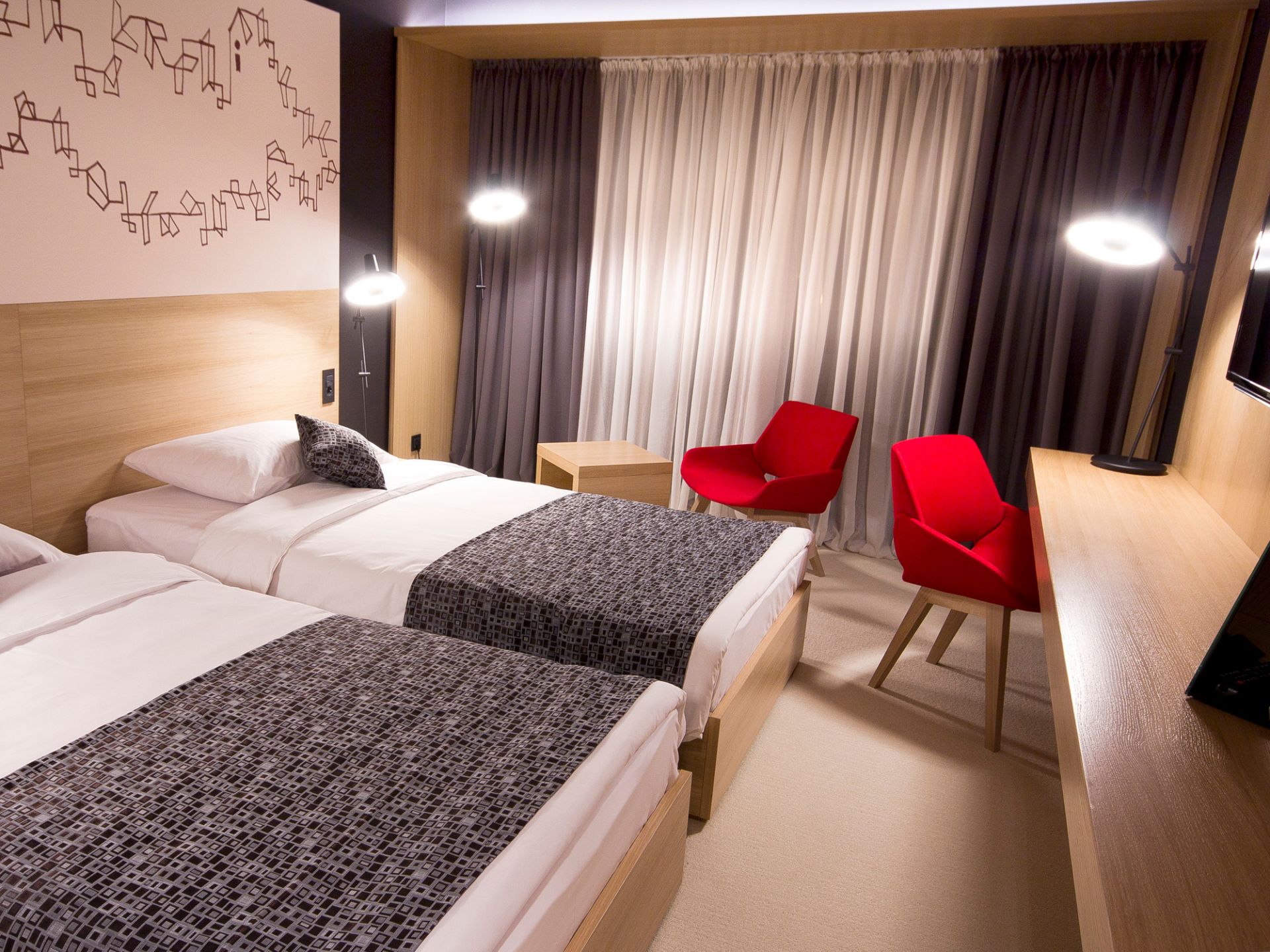 Zwei Betten im Hotelzimmer mit Arigato Stehleuchte von Grupa im Hintergrund. Designlampe spendet Licht.