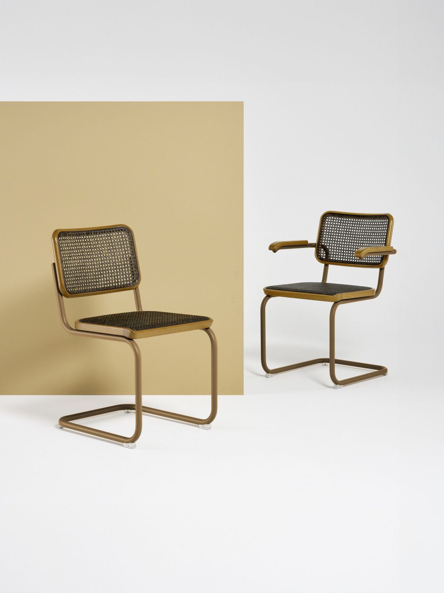 Zwei Thonet S 32 V Freischwinger Stühle mit Stahlrohrgestell und Wiener Geflecht, einer mit Armlehnen.