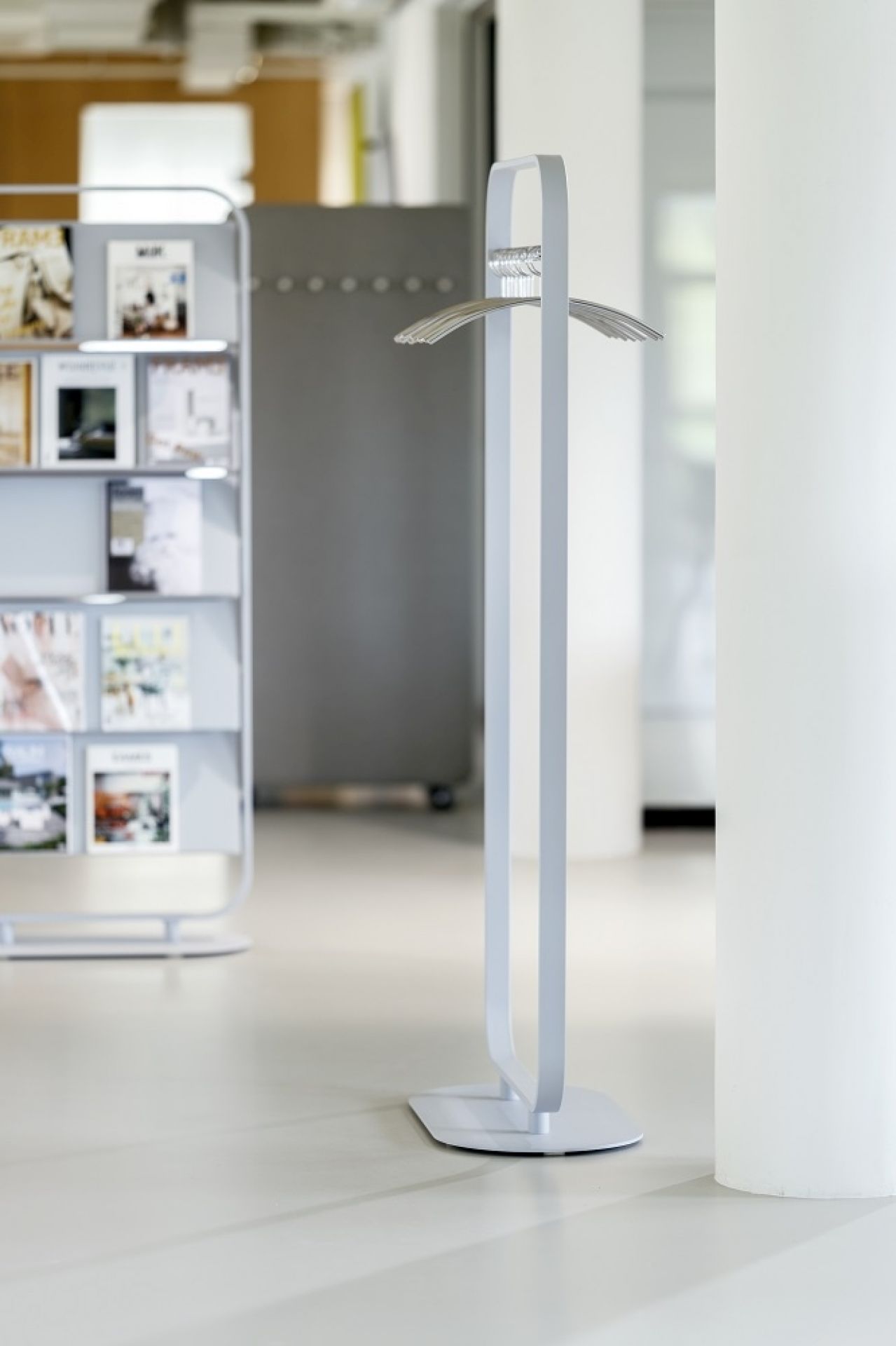 Cascando Focus Prospekthalter: Moderner, freistehender Prospektständer und Kleiderständer in hellem Grau im minimalistischen Büro.