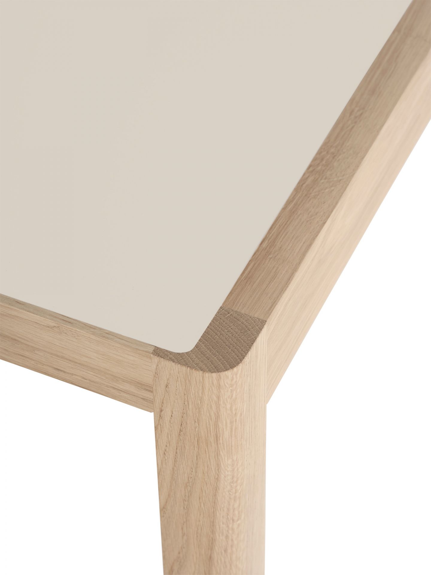 Detailaufnahme vom Muuto Workshop Table: Tischplatte in Beige mit hellem Holzrahmen und Bein.