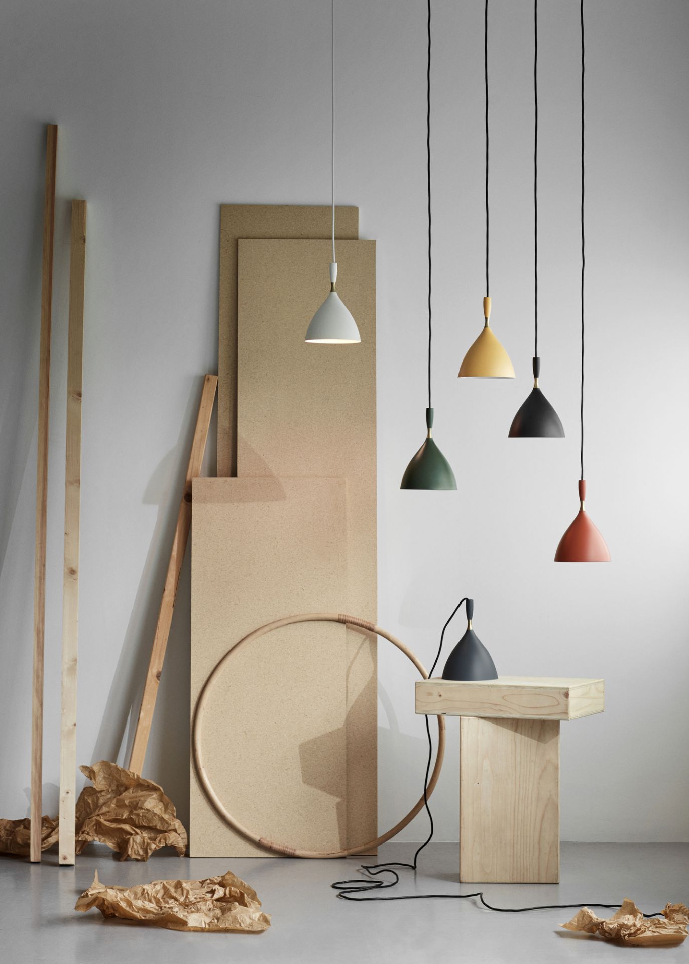 Northern Dokka Pendelleuchten in verschiedenen Farben hängen und stehen in einem minimalistischen Interieur.