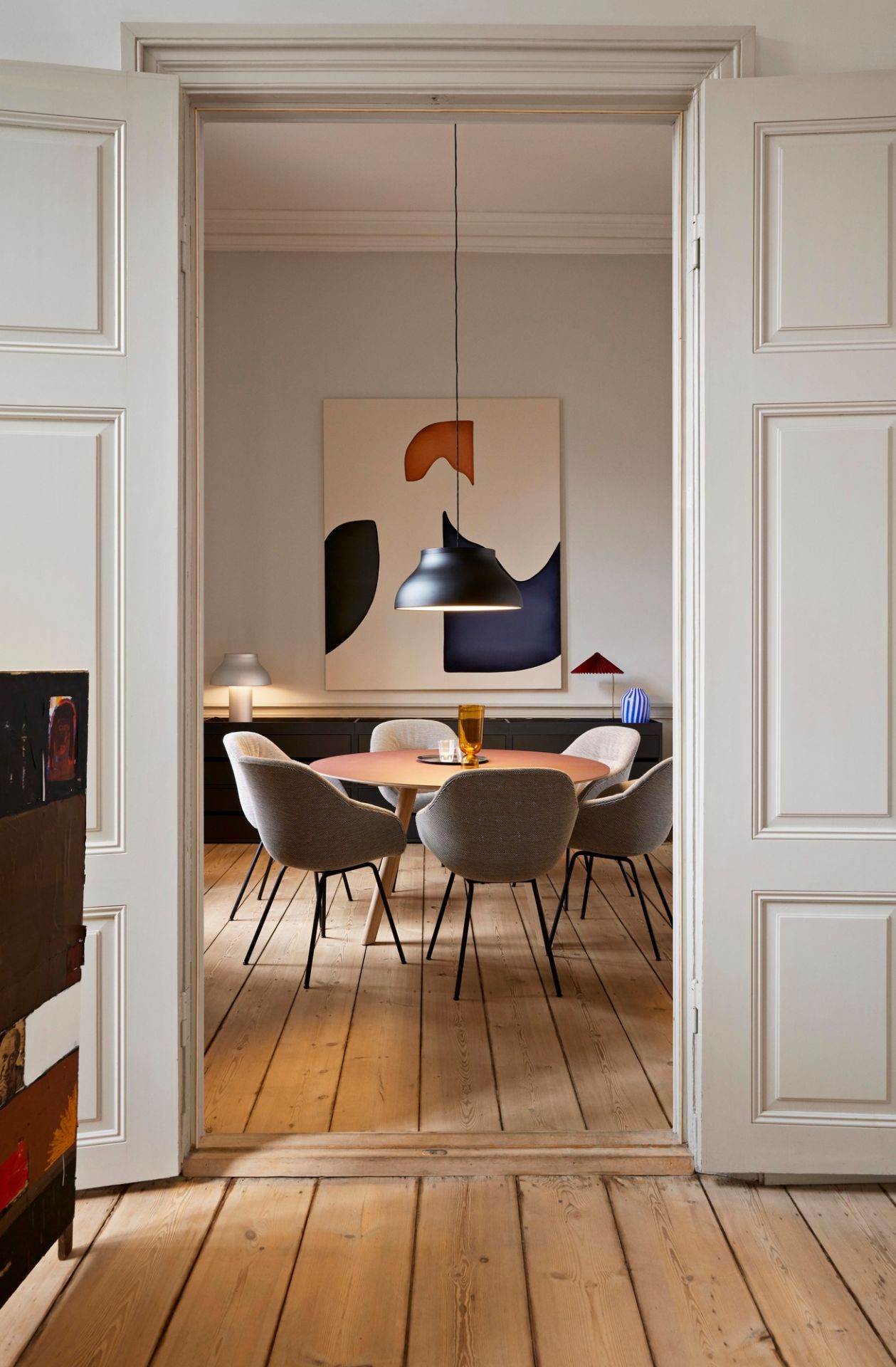 Esszimmer mit rundem Tisch und sechs grauen About a Chair AAC127 Stühlen von Hay.