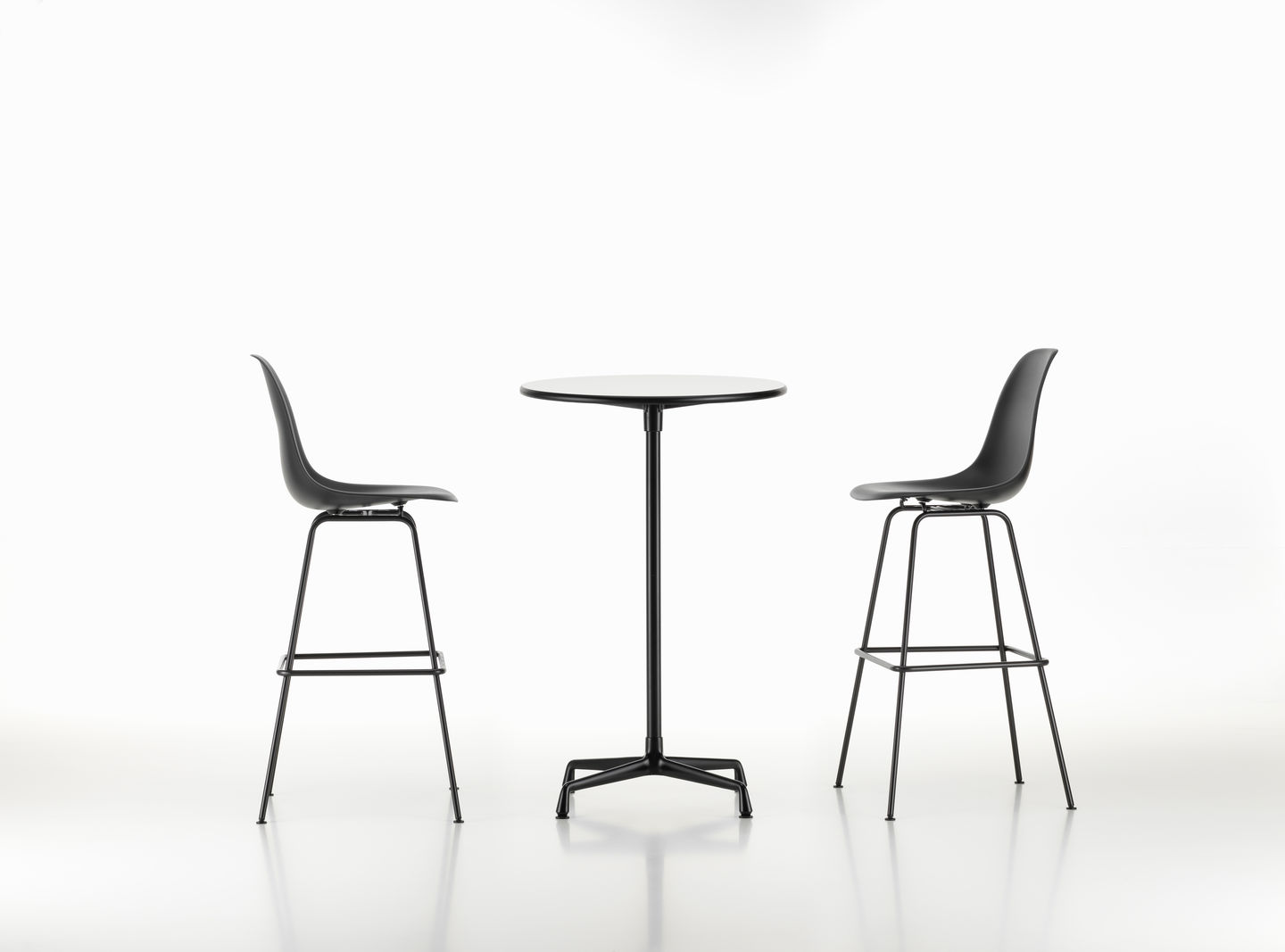 Zwei schwarze Eames Plastic Bar Stools von Vitra mit einem runden Tisch. Barhocker für Küche und Bar.