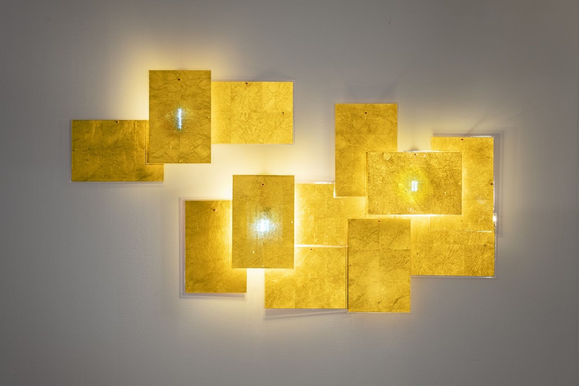 Detailaufnahme der 24 Karat Blau Wandleuchte von Ingo Maurer mit goldenen, rechteckigen Elementen.