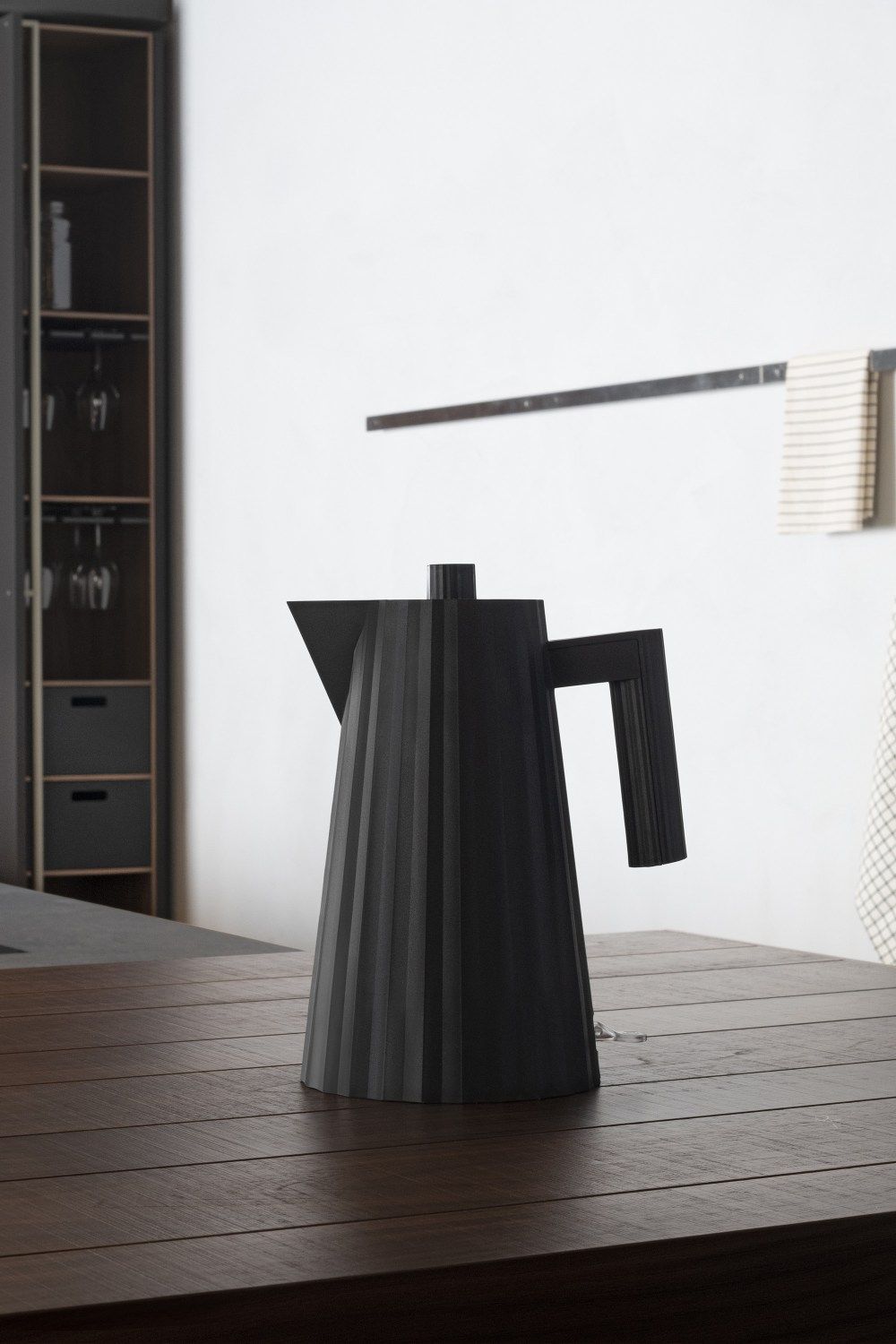 Schwarzer Alessi Plissé Wasserkocher auf Holztisch. Design Wasserkocher für Küche und Haushalt.