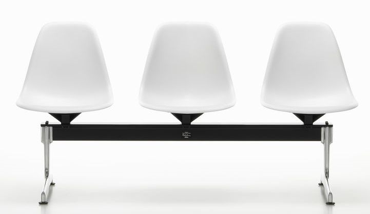 Eames Side Chair auf Traverse von Vitra, drei weiße Kunststoffschalen auf schwarzem Gestell.