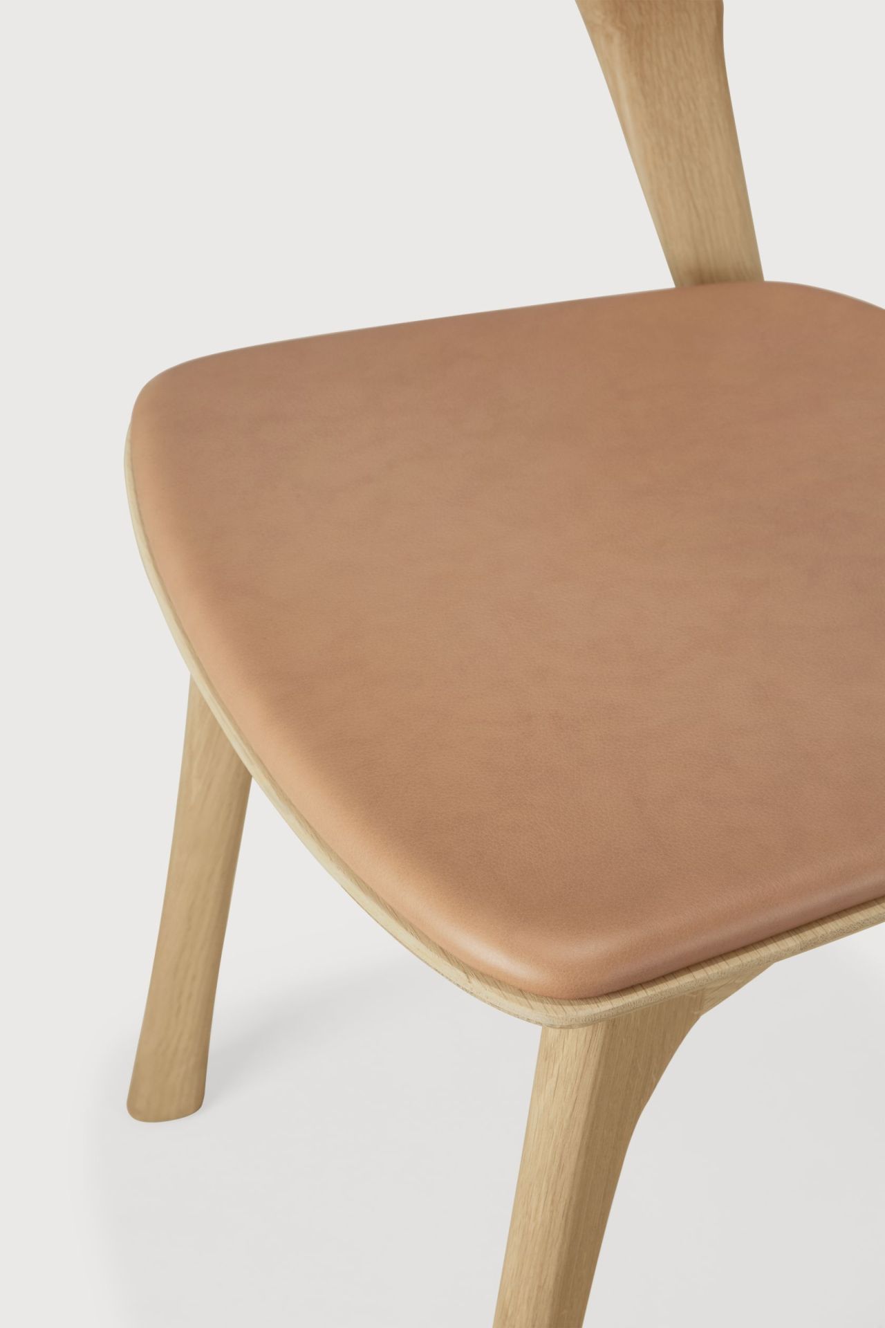 Detailaufnahme des Bok Stuhls mit lackierter Eiche und Sienna Leder Sitzfläche. Design Stuhl.