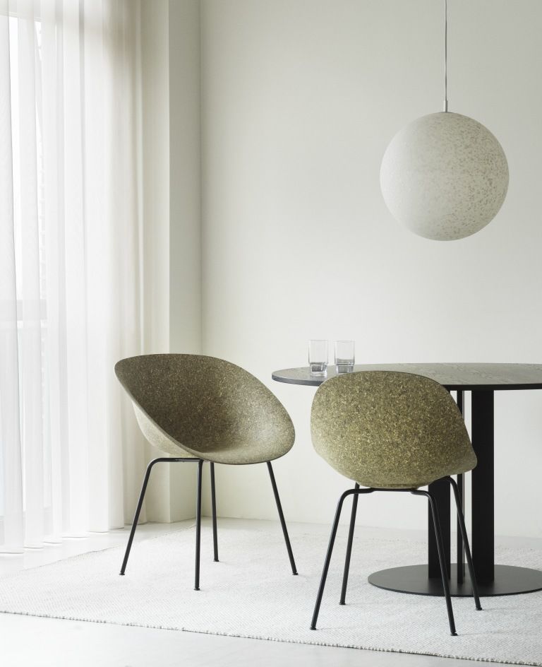 Zwei Normann Copenhagen Mat Armchair Stühle mit Stahlgestell in olivgrün am Esstisch.