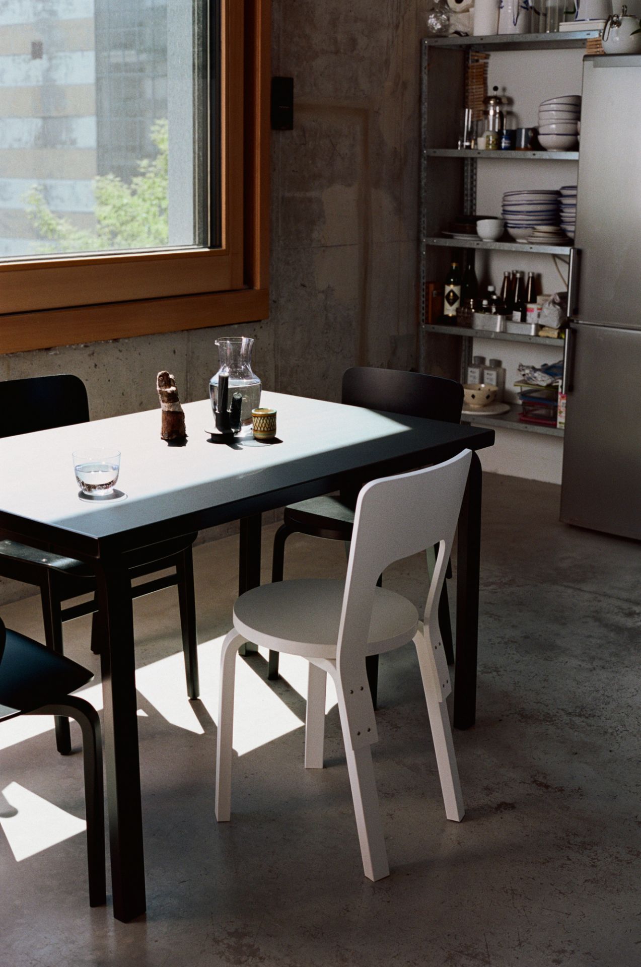 Grau lackierter Aslak Stuhl von Artek am Esstisch in modernem Interieur. Designklassiker.
