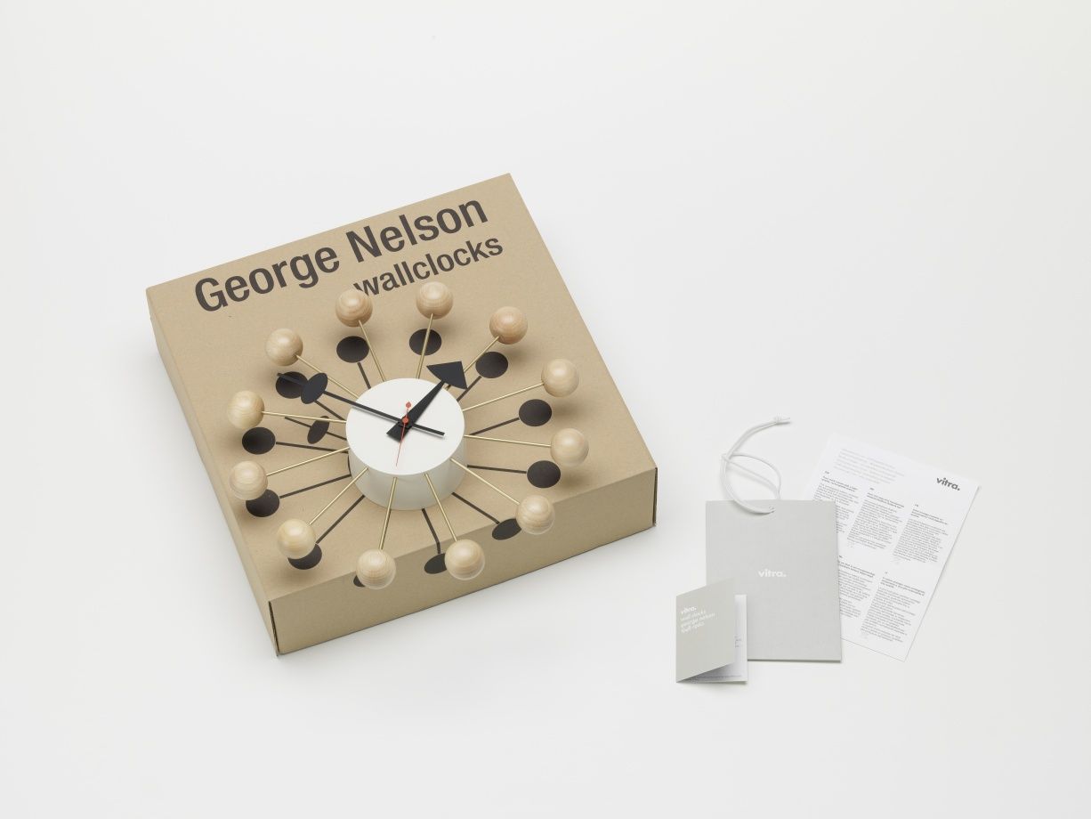 Vitra Ball Clock Wanduhr aus Buchenholz, eine moderne Design-Uhr auf einem Karton.