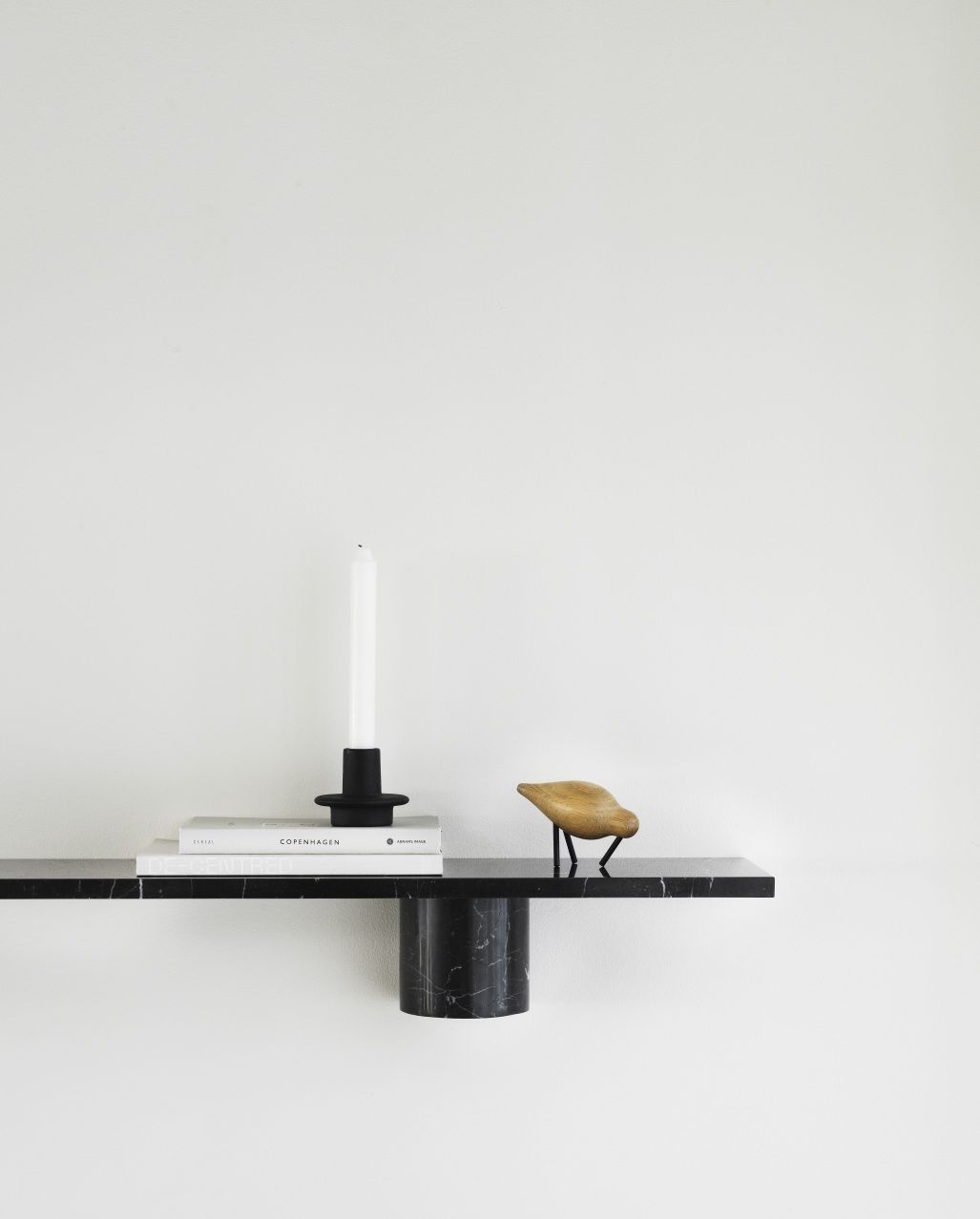 Schwarzes Sten Regal von Normann Copenhagen mit Dekoartikeln an einer weißen Wand.