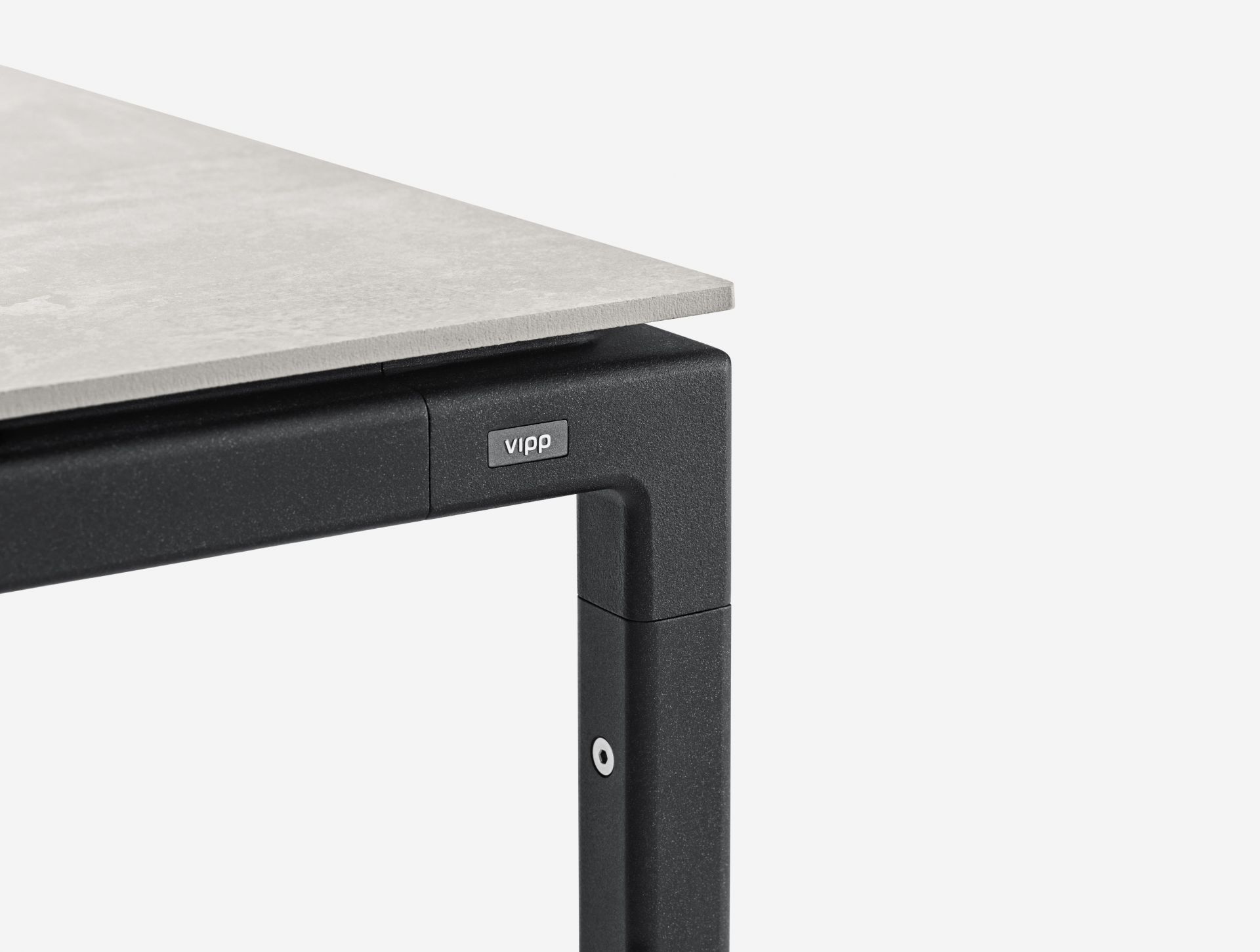 Detailaufnahme vom Vipp Tisch Medium mit hellgrauer Tischplatte und schwarzem Metallgestell, modernes Design.