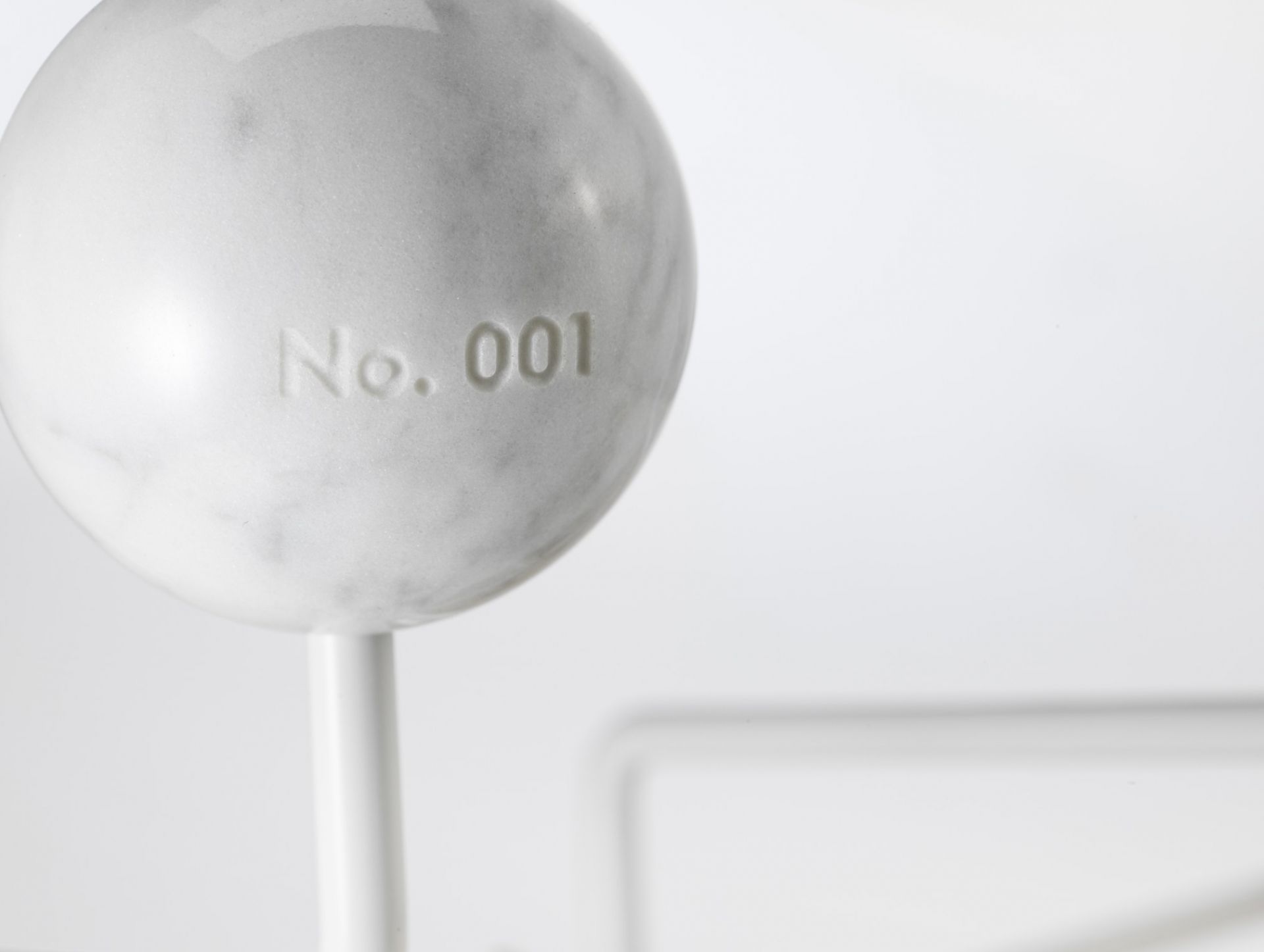 Detailaufnahme einer Marmorkugel der Eames Hang it all Garderobe Limited Edition, Nummer 001.