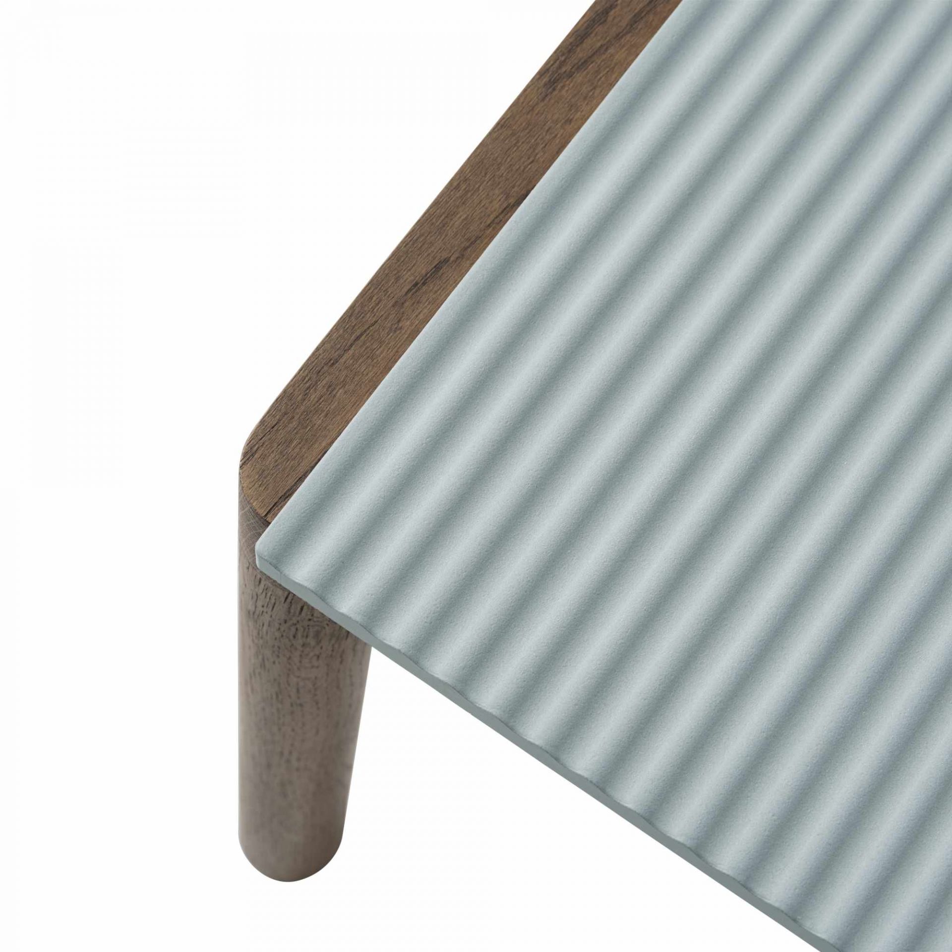 Detailaufnahme des Muuto Couple Coffee Table: Holzrahmen, geriffelte, hellblaue Tischplatte und ein Tischbein.