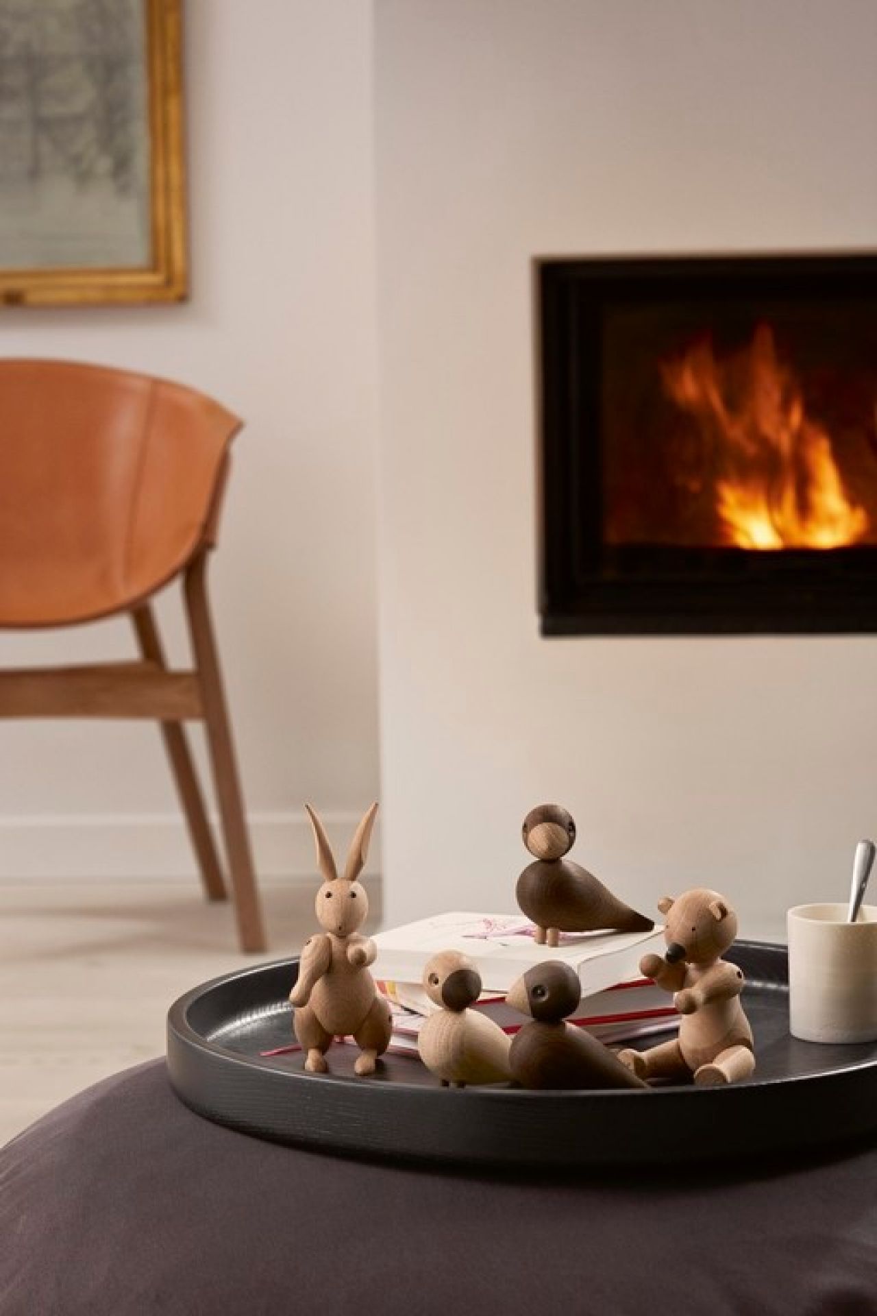 Kay Bojesen Holzfiguren: Unzertrennliche Lovebirds, Hase und Bär auf einem Tablett vor einem Kamin.