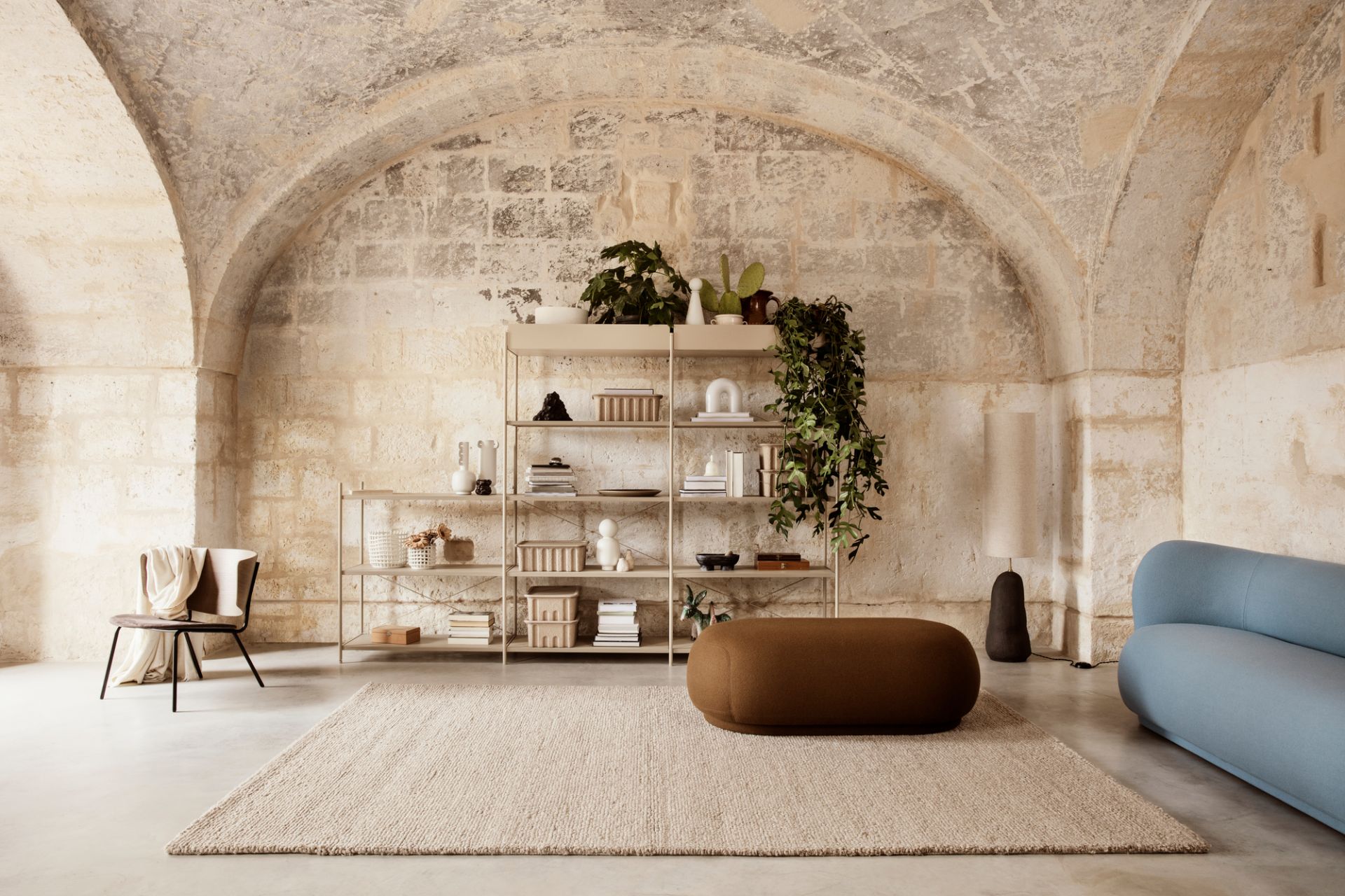 Nahaufnahme der Ferm Living Vuelta Lampe Tischleuchte in einem stilvollen Wohnzimmer mit Regalen und Dekoration.