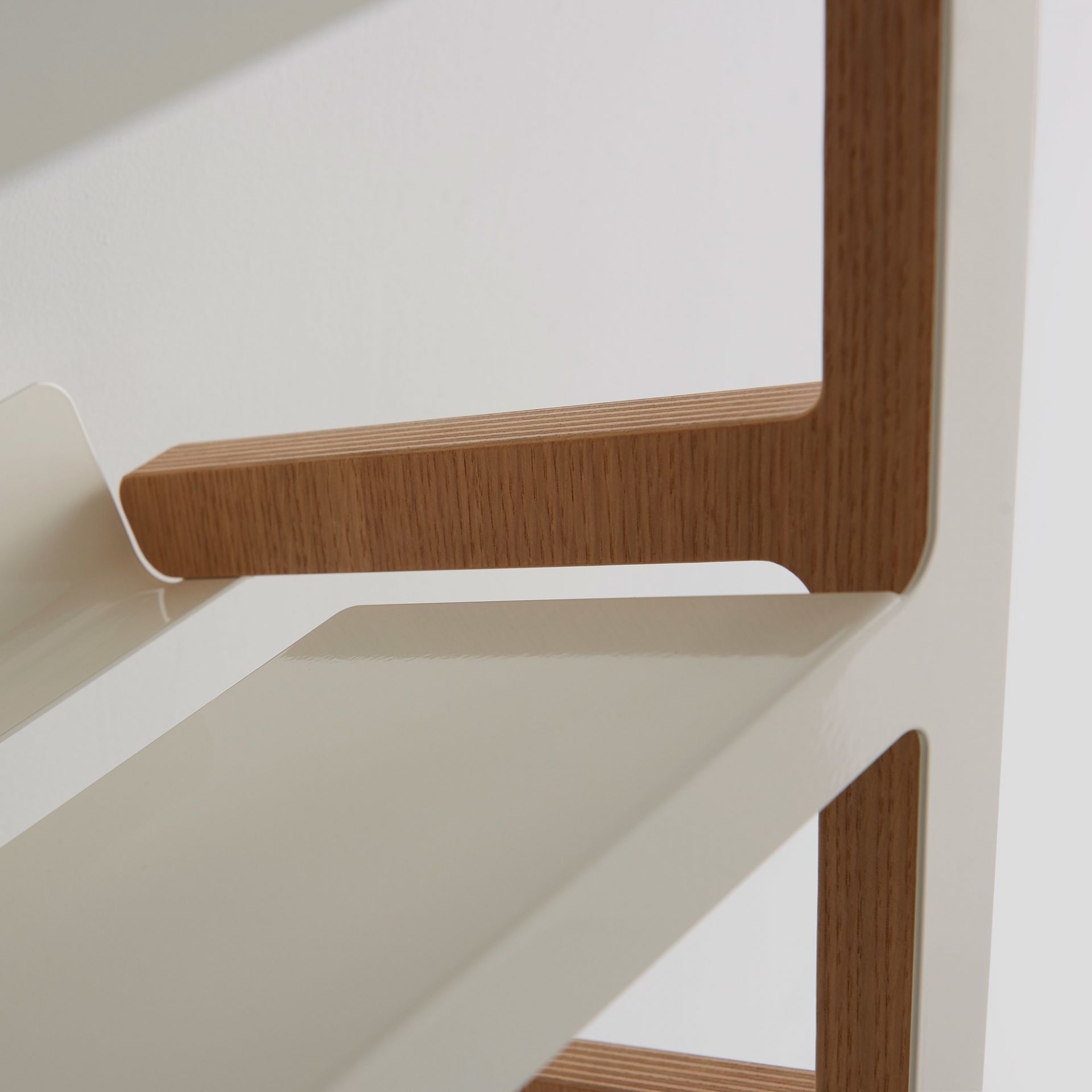 Detailaufnahme eines weißen Regals mit Holzdetails für moderne Wohnraumgestaltung.