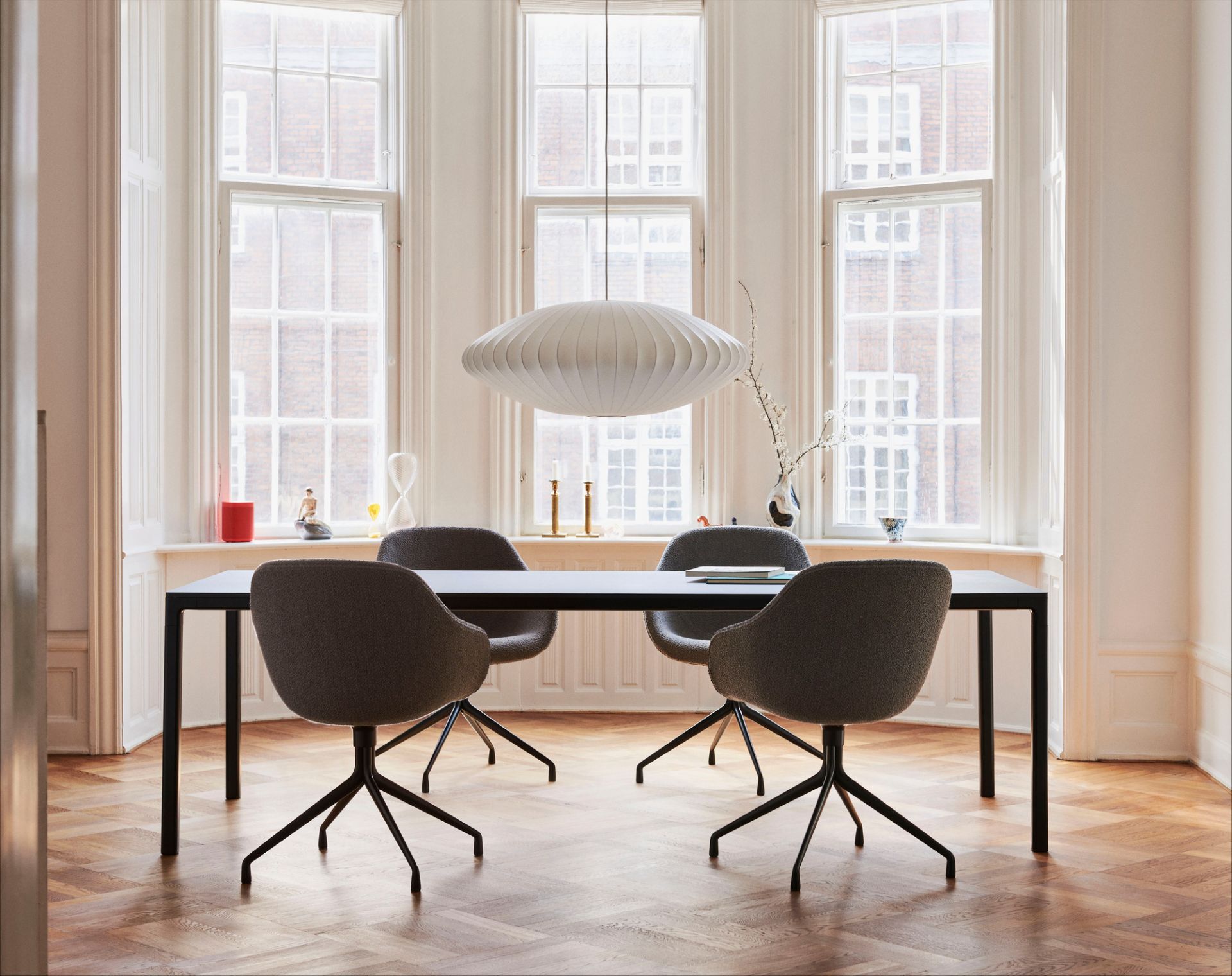 Esszimmer mit schwarzem Tisch und vier grauen About a Chair AAC121 Soft Duo Stühlen von Hay.