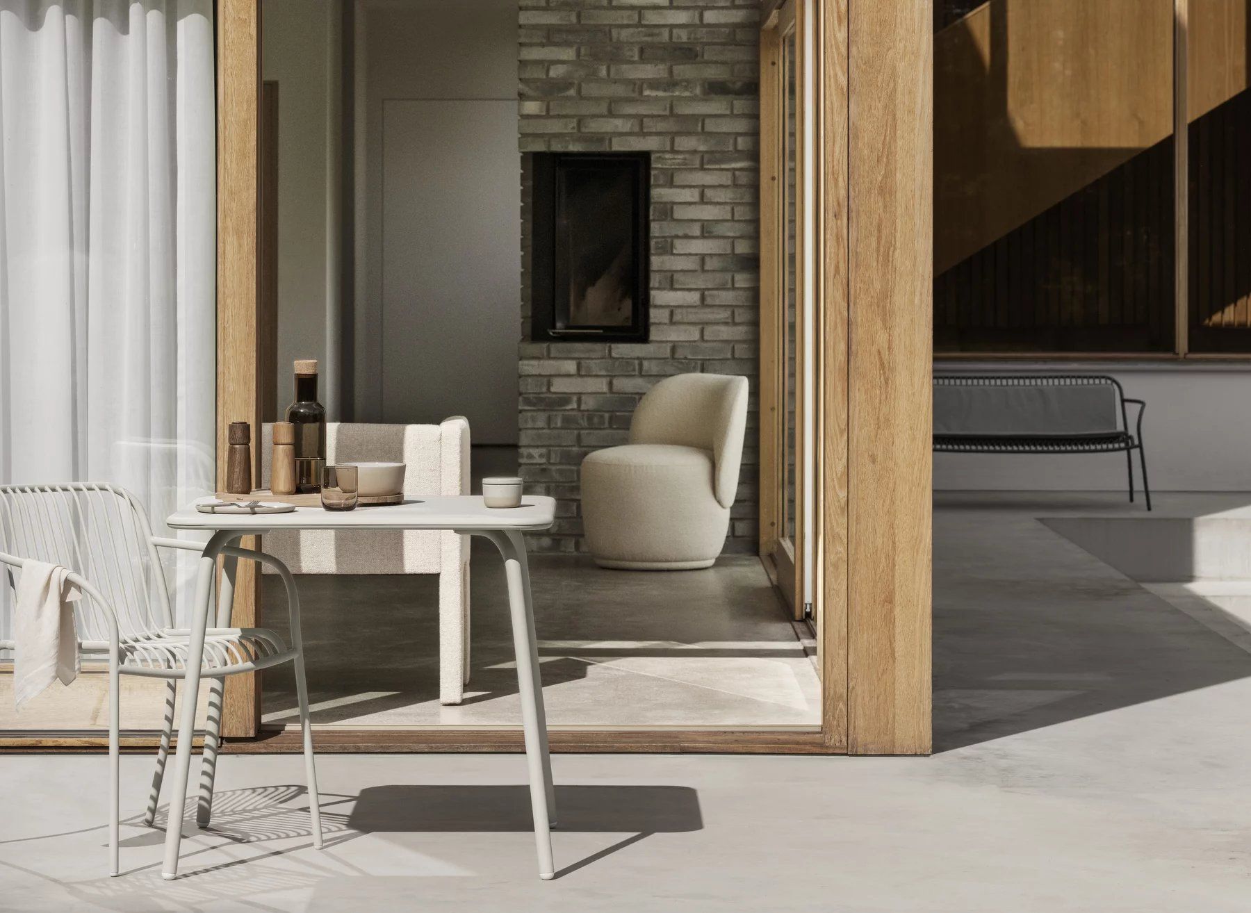 Blomus Yua Armlehnstuhl in Silk Gray am Gartentisch, moderne Outdoor Möbel für Terrasse und Balkon.