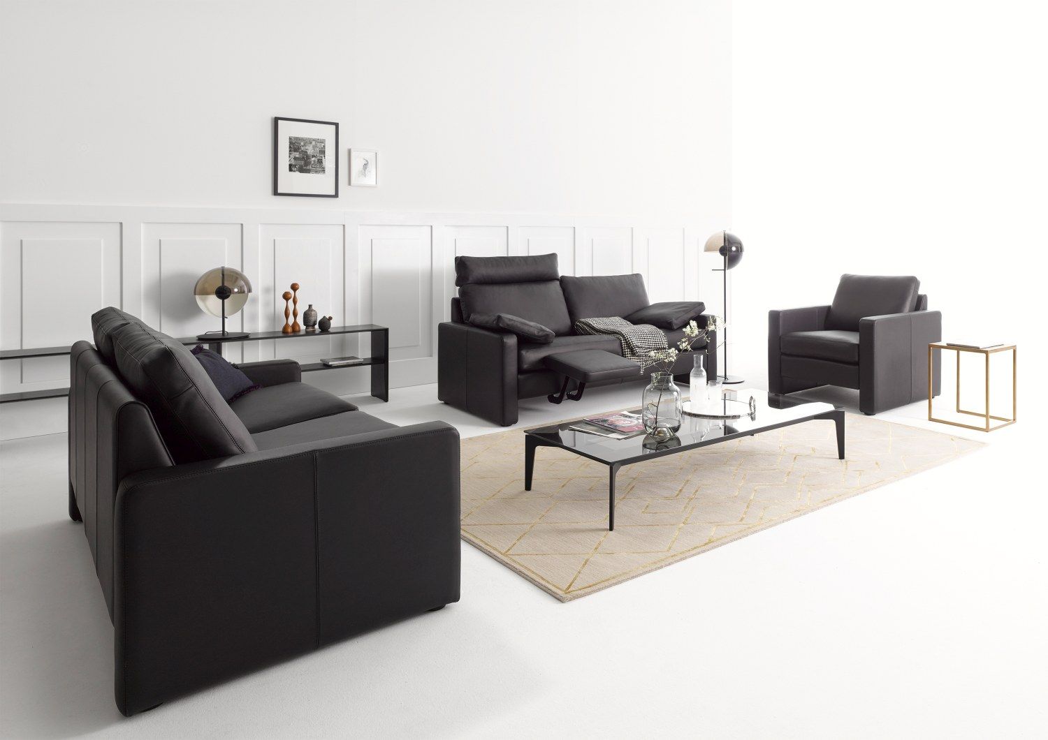 Schwarze Conseta Sofa Konfiguration Cor mit Sessel und Couchtisch in modernem Wohnzimmer Ambiente.