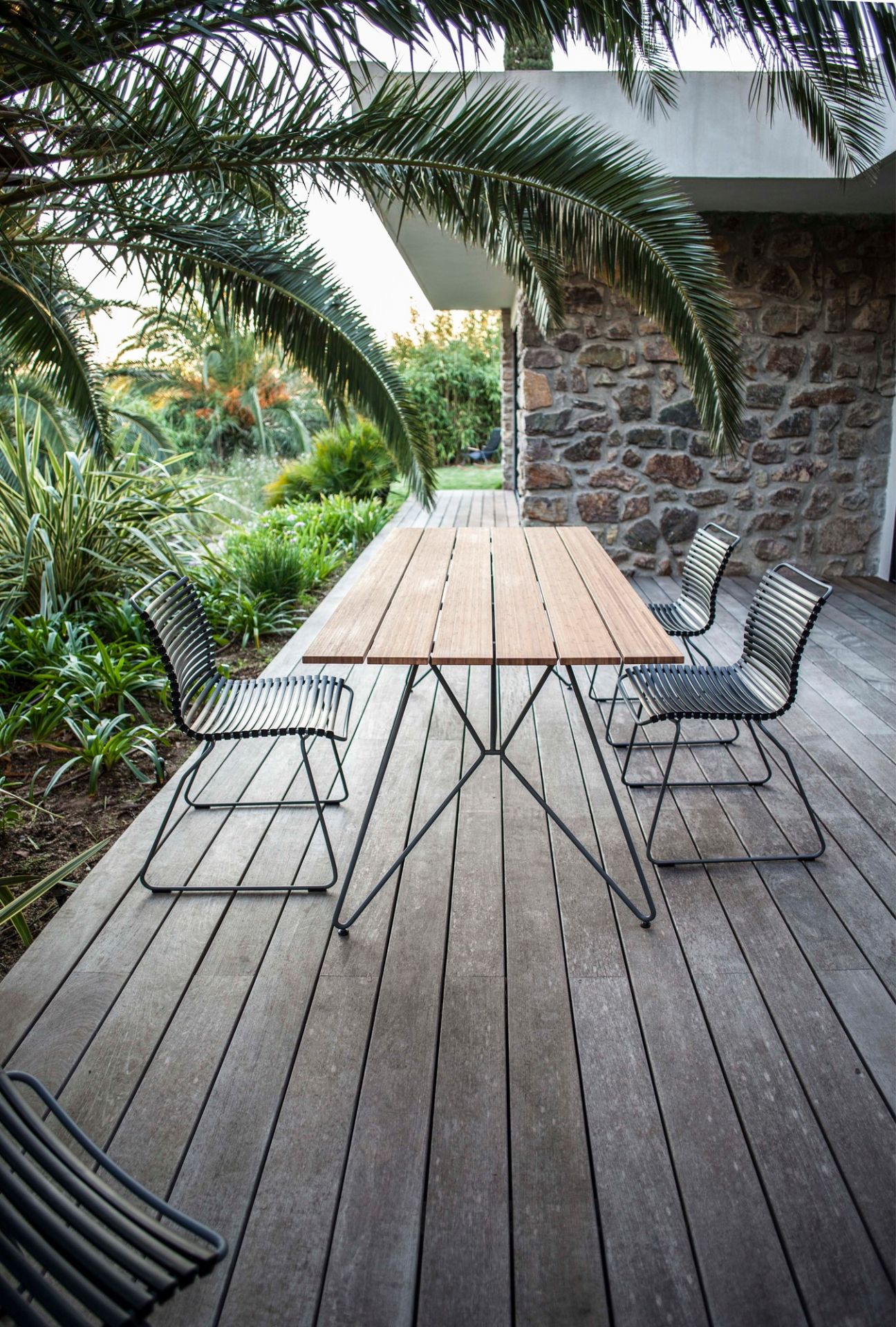 Houe Click Stuhl ohne Armlehne und Esstisch auf Holzterrasse im Garten. Outdoor Möbel.