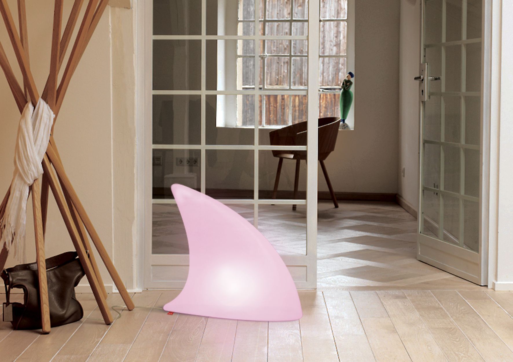 Moree Shark Haifischflosse Bodenleuchte, pink, im modernen Wohnzimmer auf hellem Holzboden, stimmungsvolle Beleuchtung.