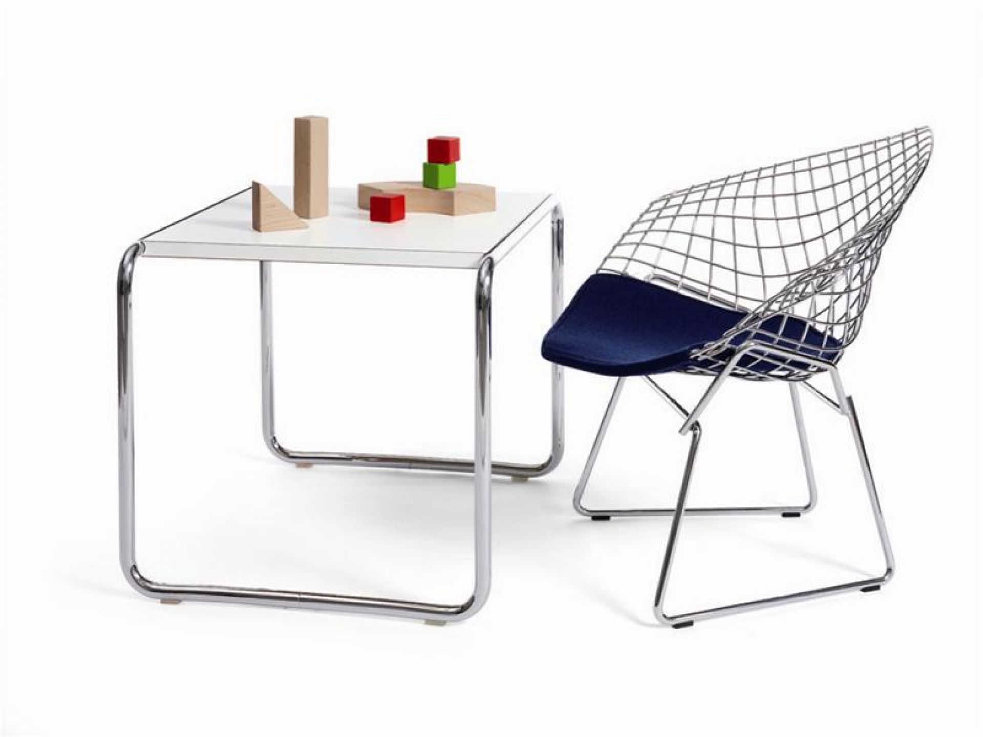 Weißer Laccio Couchtisch klein von Knoll International mit Spielzeug und einem Drahtsessel.