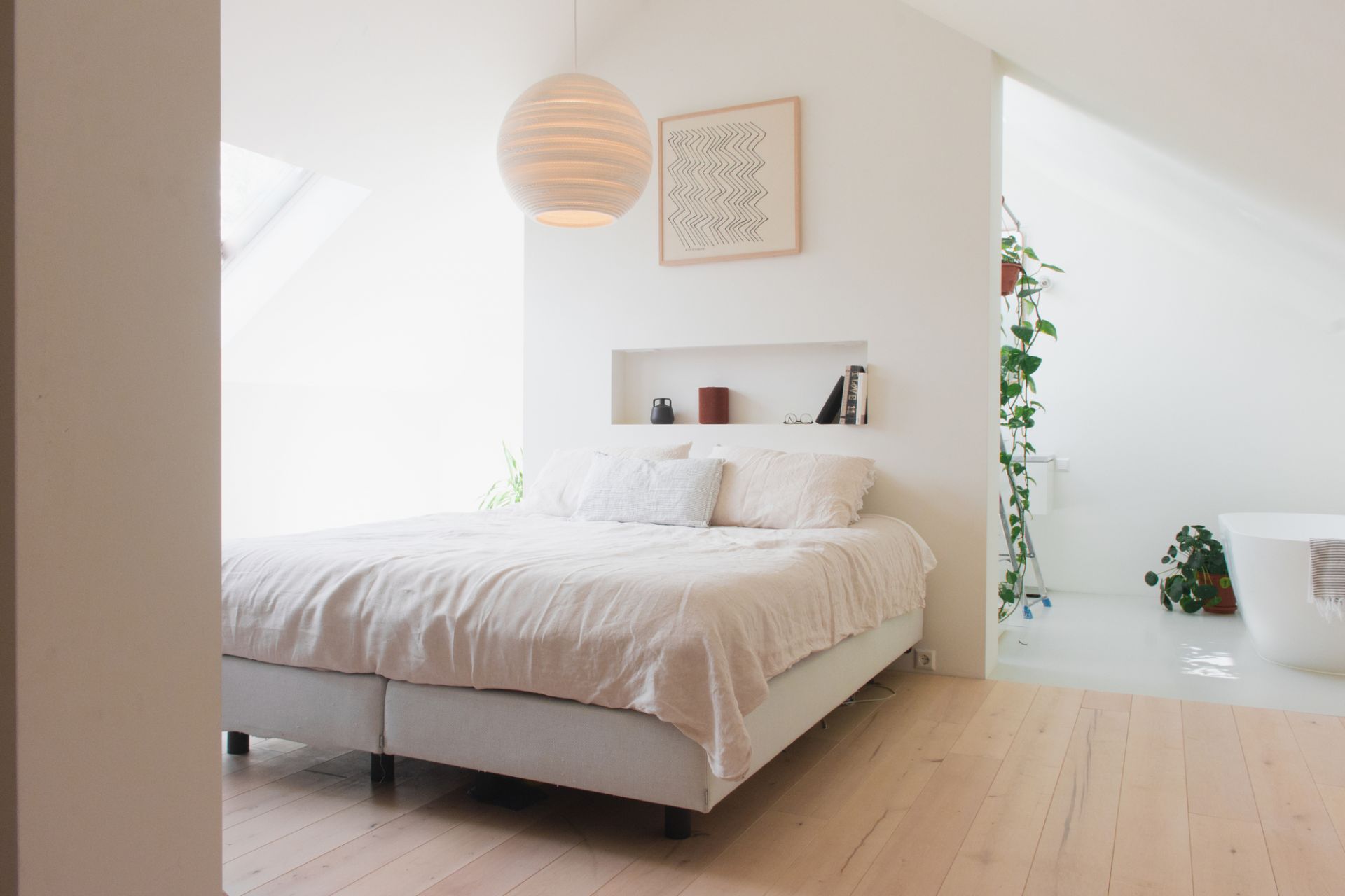 Helles Schlafzimmer mit Graypants Scraplights Moon Hängeleuchte in Weiß, die über dem Bett hängt.