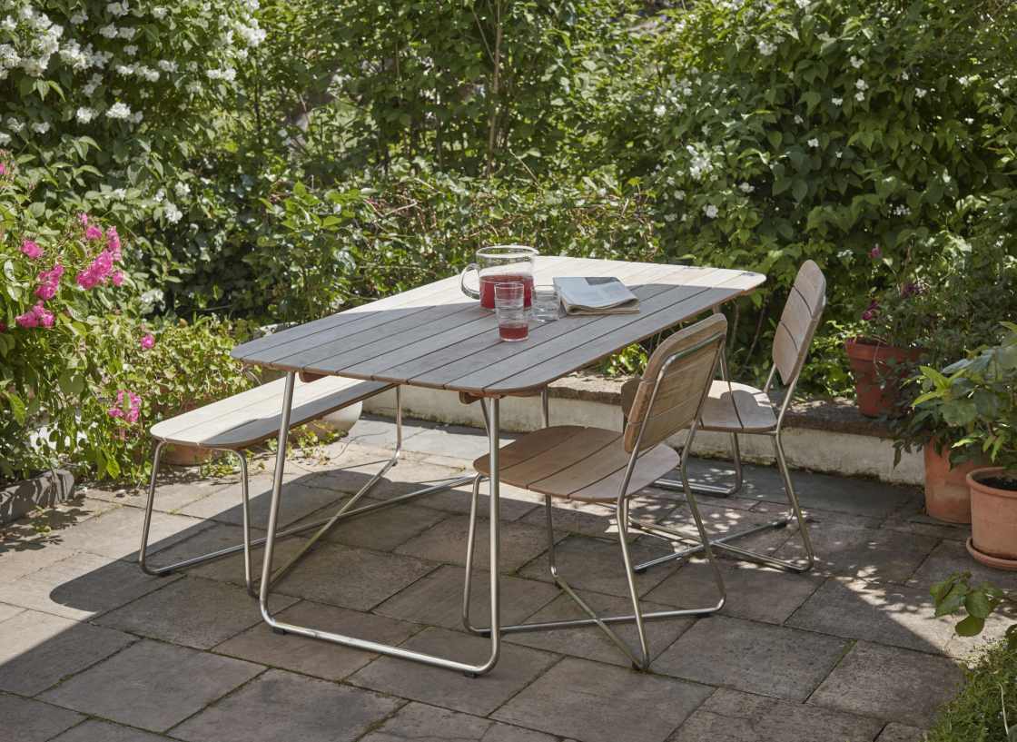 Lilium Bank von Skagerak by Fritz Hansen: Gartenmöbel-Set mit Tisch, Bank und Stühlen im Freien.