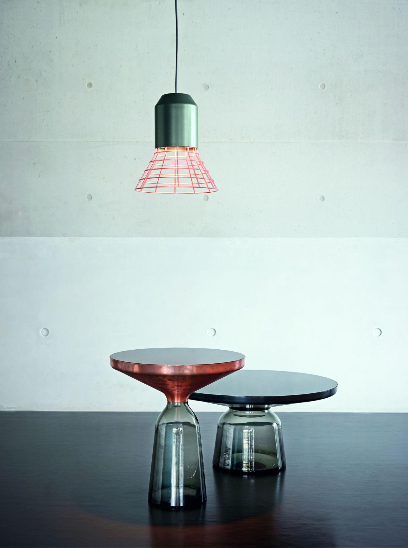 Zwei ClassiCon Bell Coffee Tables mit Marmor Tischplatten in Kupfer und Schwarz unter Lampe.