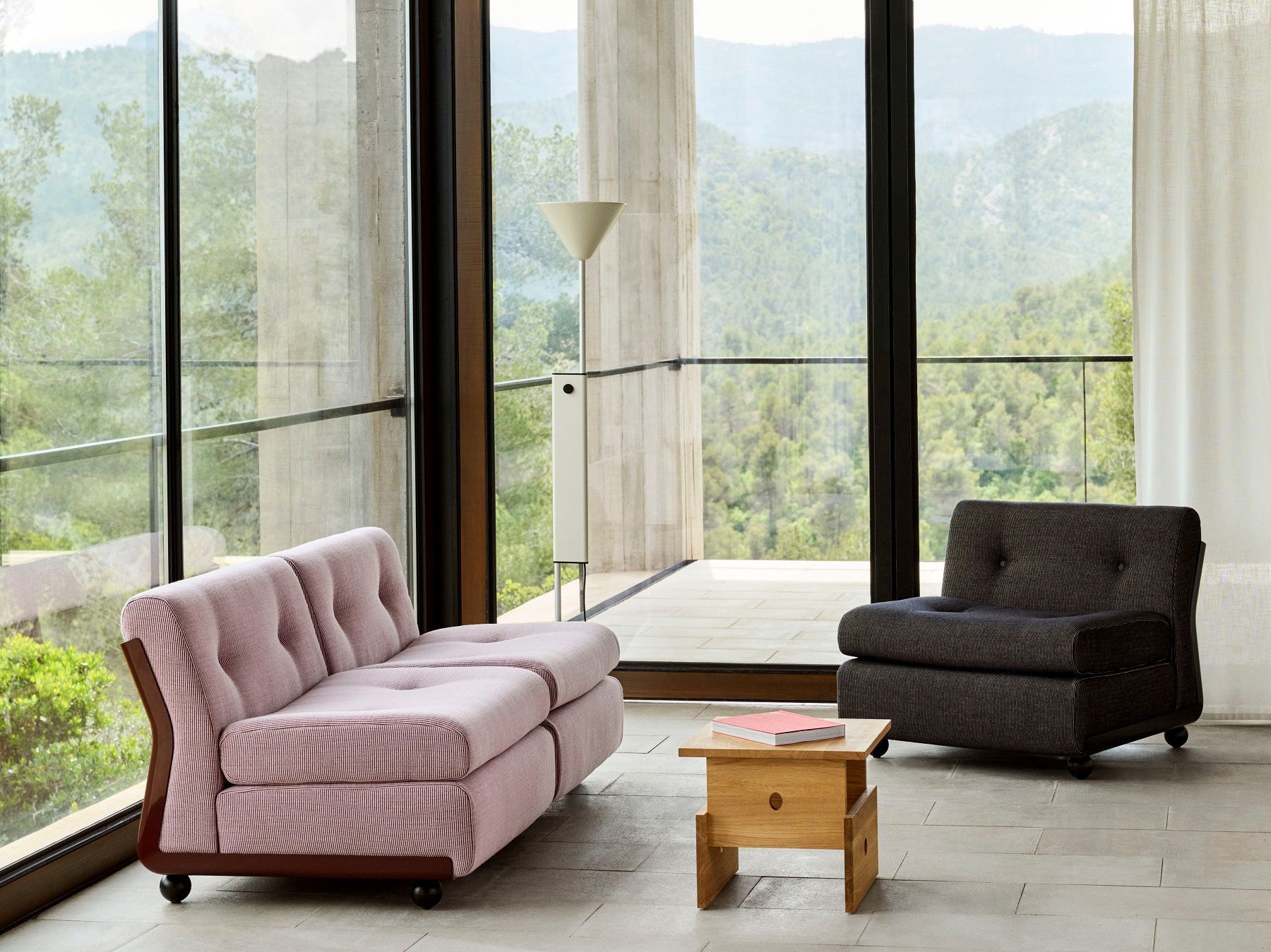 Helle, moderne Inneneinrichtung mit Hay Twist Floor Lamp Stehleuchte, Sofa und Sessel vor Panoramafenster.