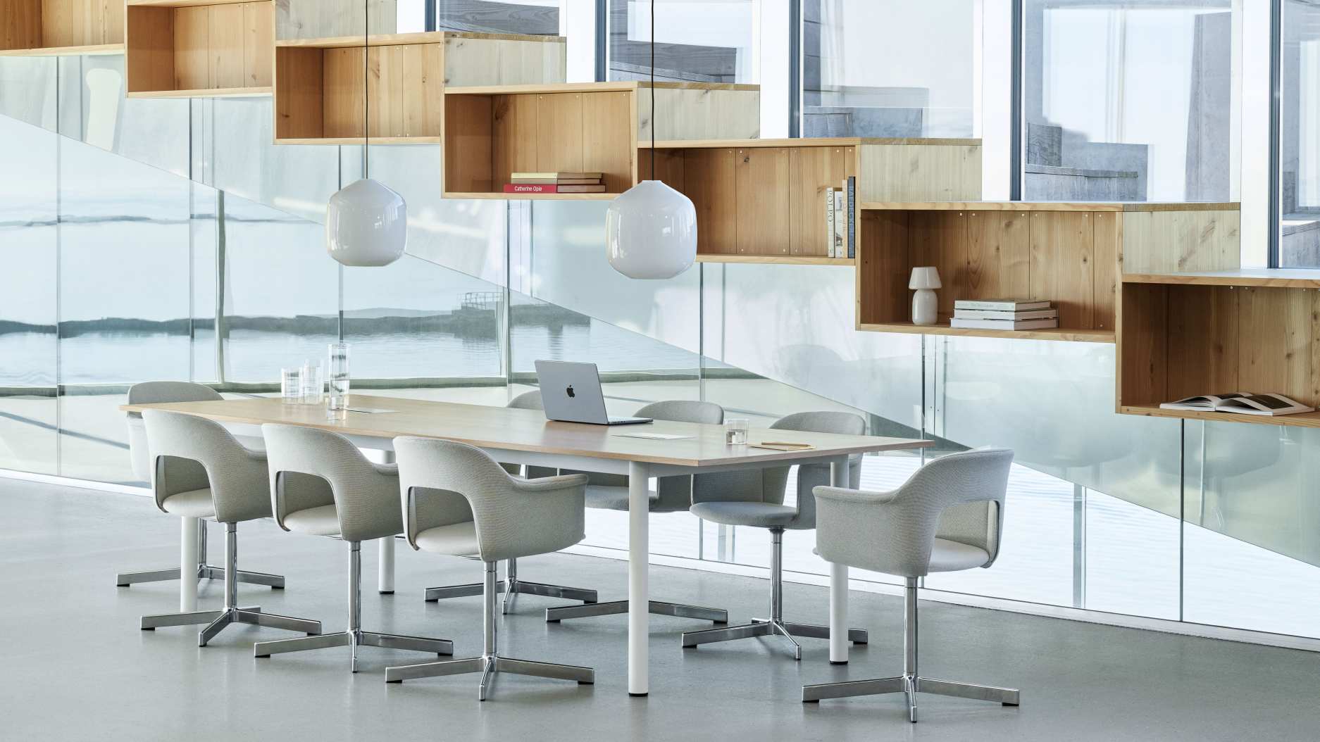 Annex Table Overhang Esstisch von Hay mit Stühlen in einem modernen Büro mit Regalen.