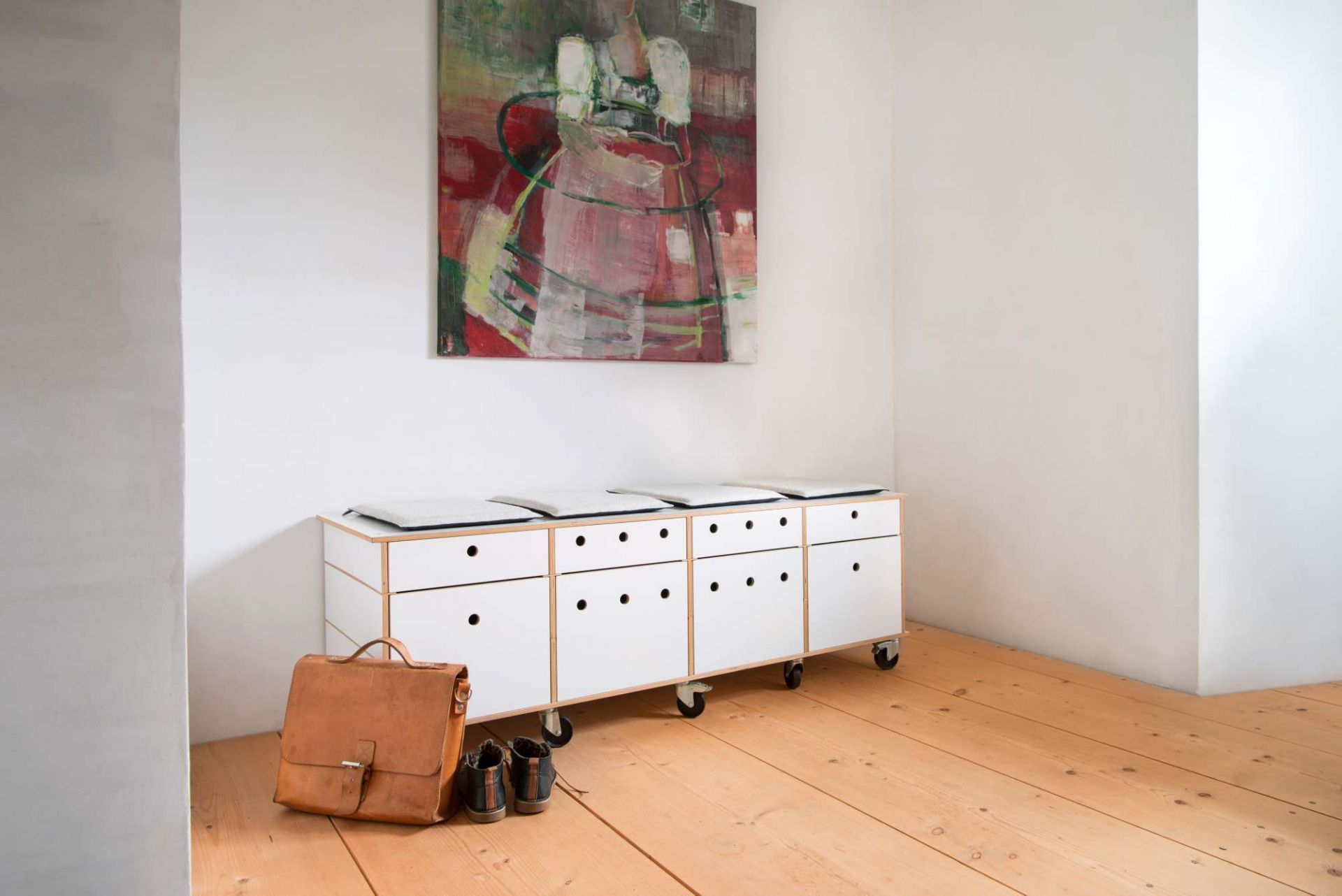 Setzen 6 von Moormann mit Sitzkissen: Weißes Sideboard mit Schubladen und grauen Sitzauflagen.