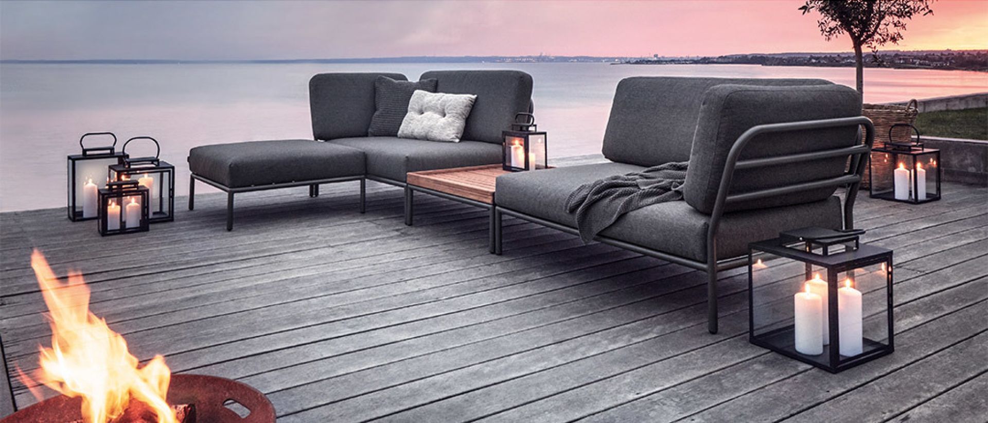 Level 2 Ottoman Outdoor Lounge Möbel Set mit Feuerstelle und Laternen am See.