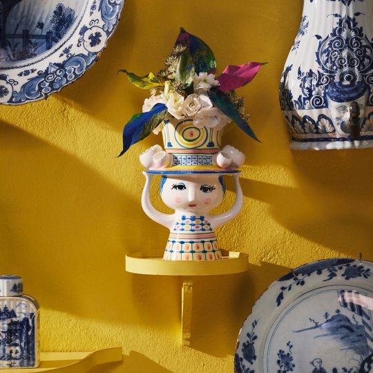 Frauenkopf-Vase von Bjorn Wiinblad mit Blumen auf gelbem Hintergrund, dekorative Keramik-Vase im Retro-Design.
