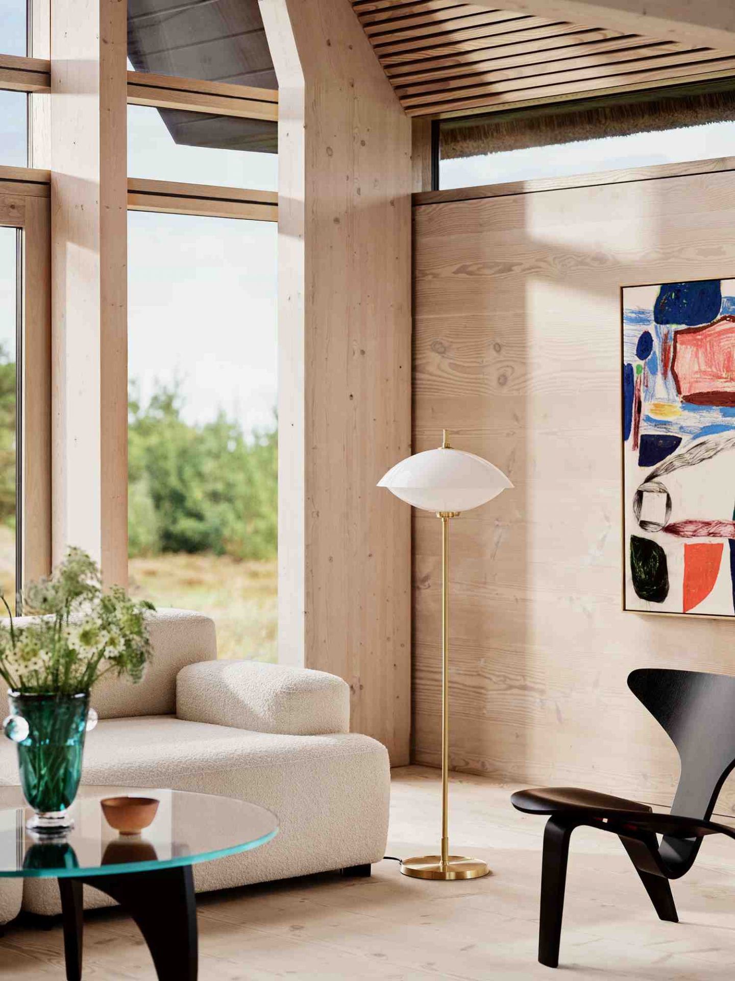 Clam Floor Lamp Stehleuchte von Fritz Hansen in modernem Wohnzimmer mit Sofa und Kunst.