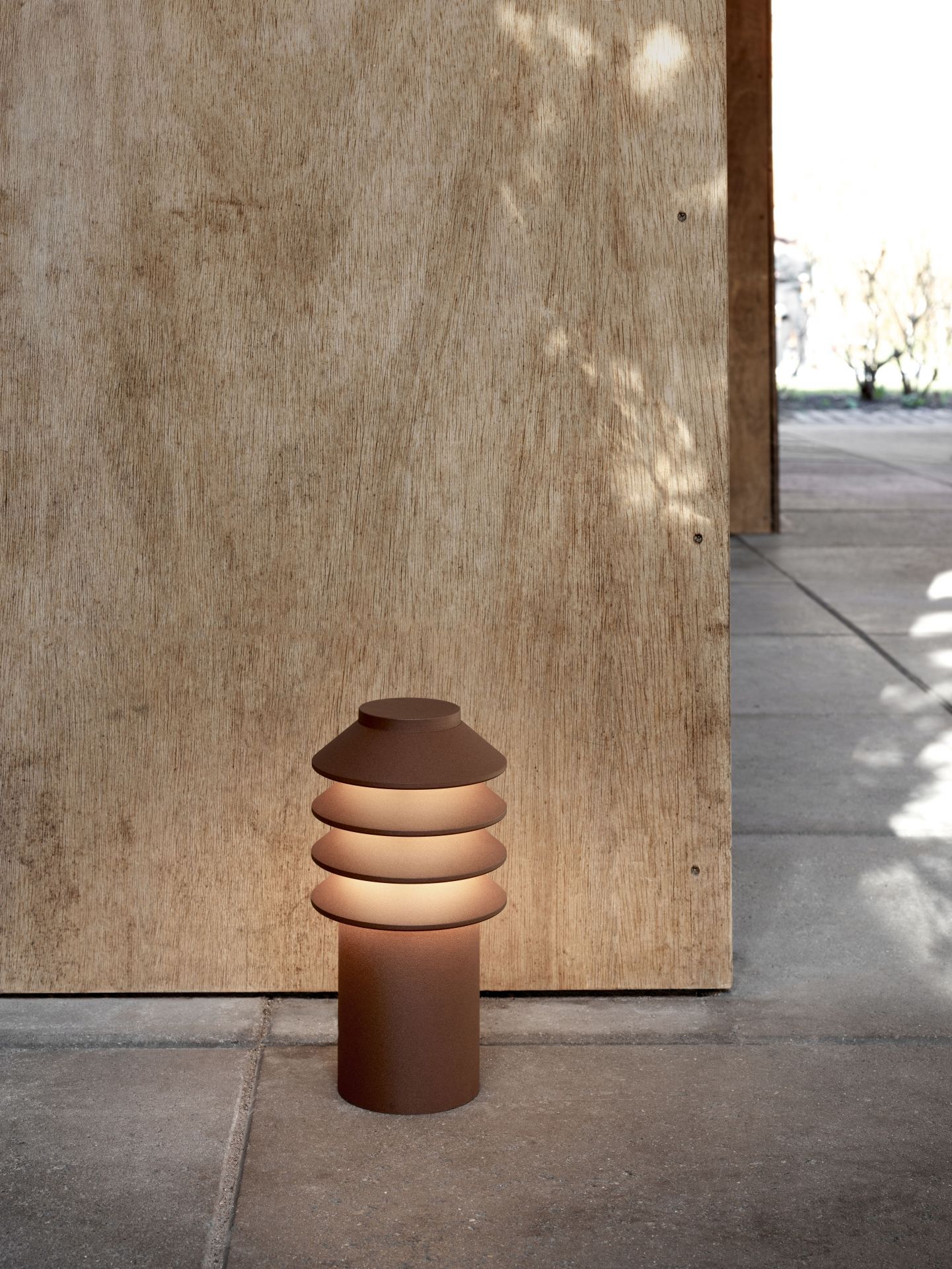 Nahaufnahme der Louis Poulsen Bysted Garden Pollerleuchte im Außenbereich, warmes Licht, modernes Design.