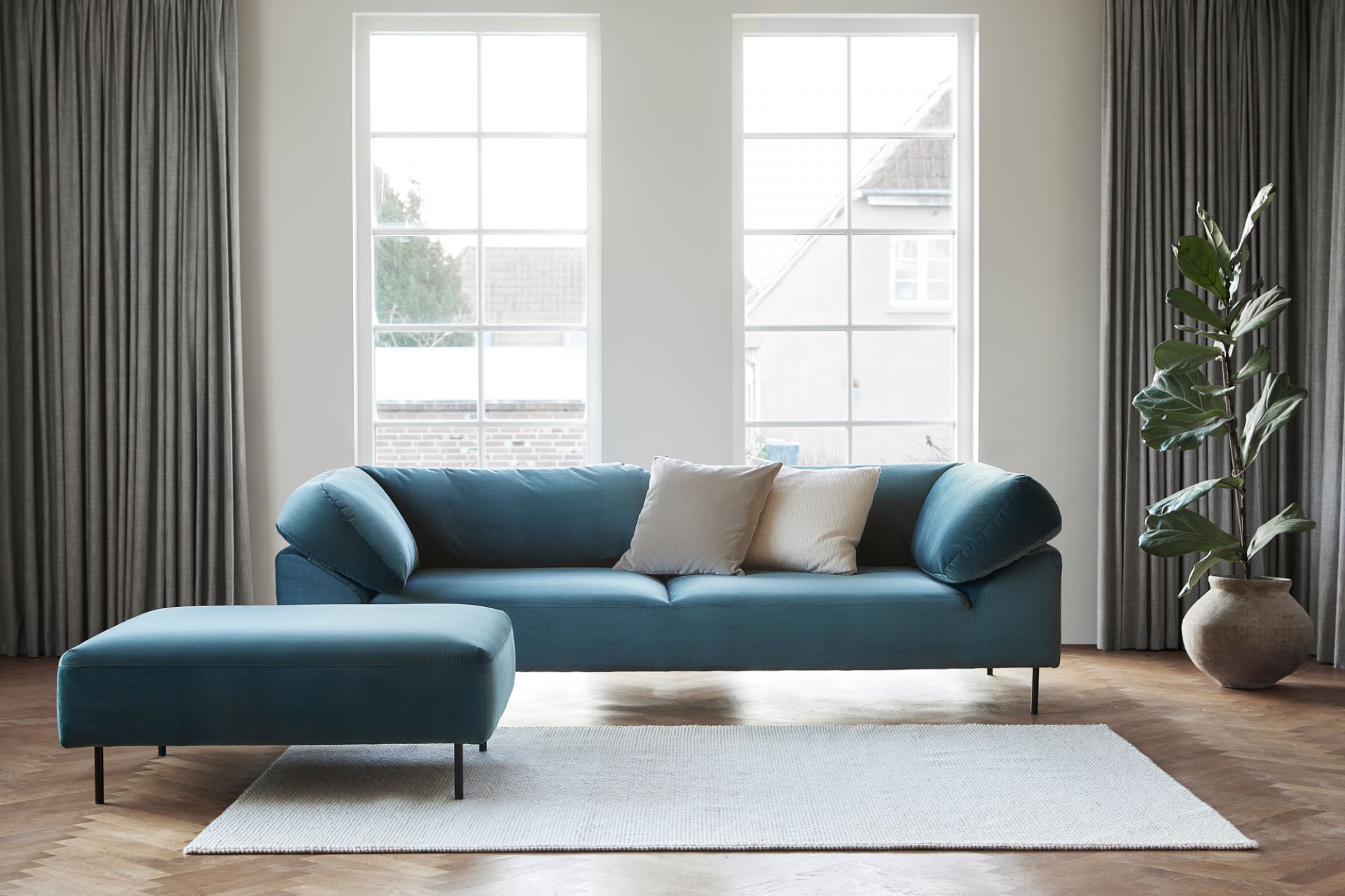 Weißgrauer Tact Teppich von Woud (170x240cm) im Wohnzimmer mit Sofa und Holzboden. Moderner Teppich für stilvolles Wohnen.