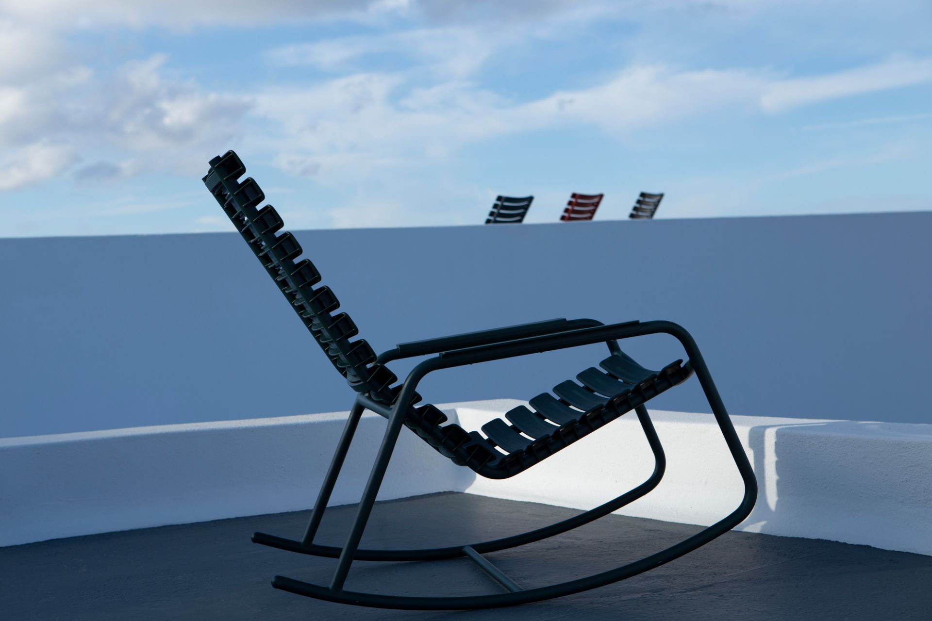 Houe ReClips Schaukelstuhl für den Außenbereich, modernes Design mit Kunststofflamellen und Metallgestell.