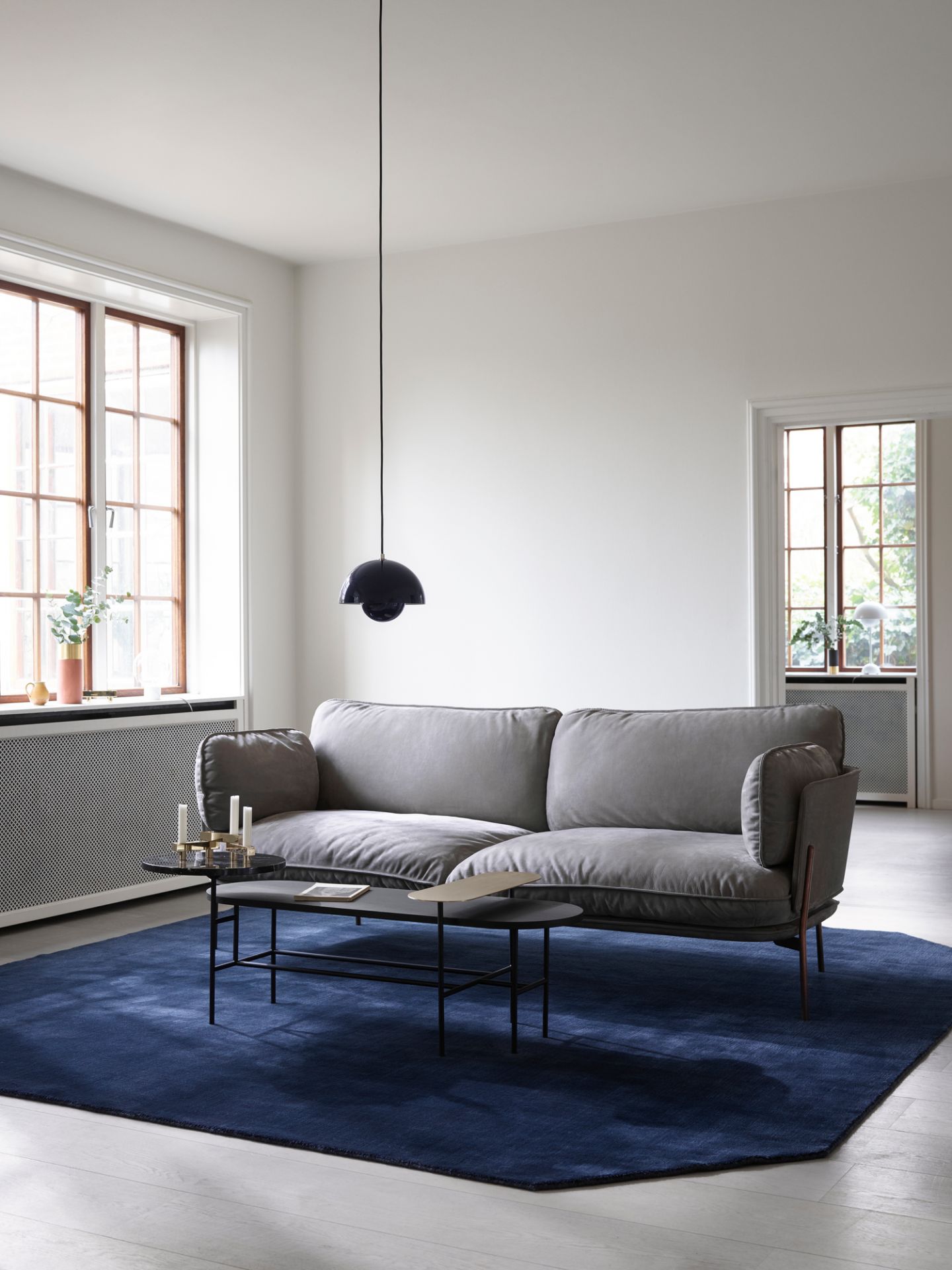 Graues Cloud Sofa von AndTradition im Wohnzimmer mit Teppich und Beistelltisch, modernes skandinavisches Design.